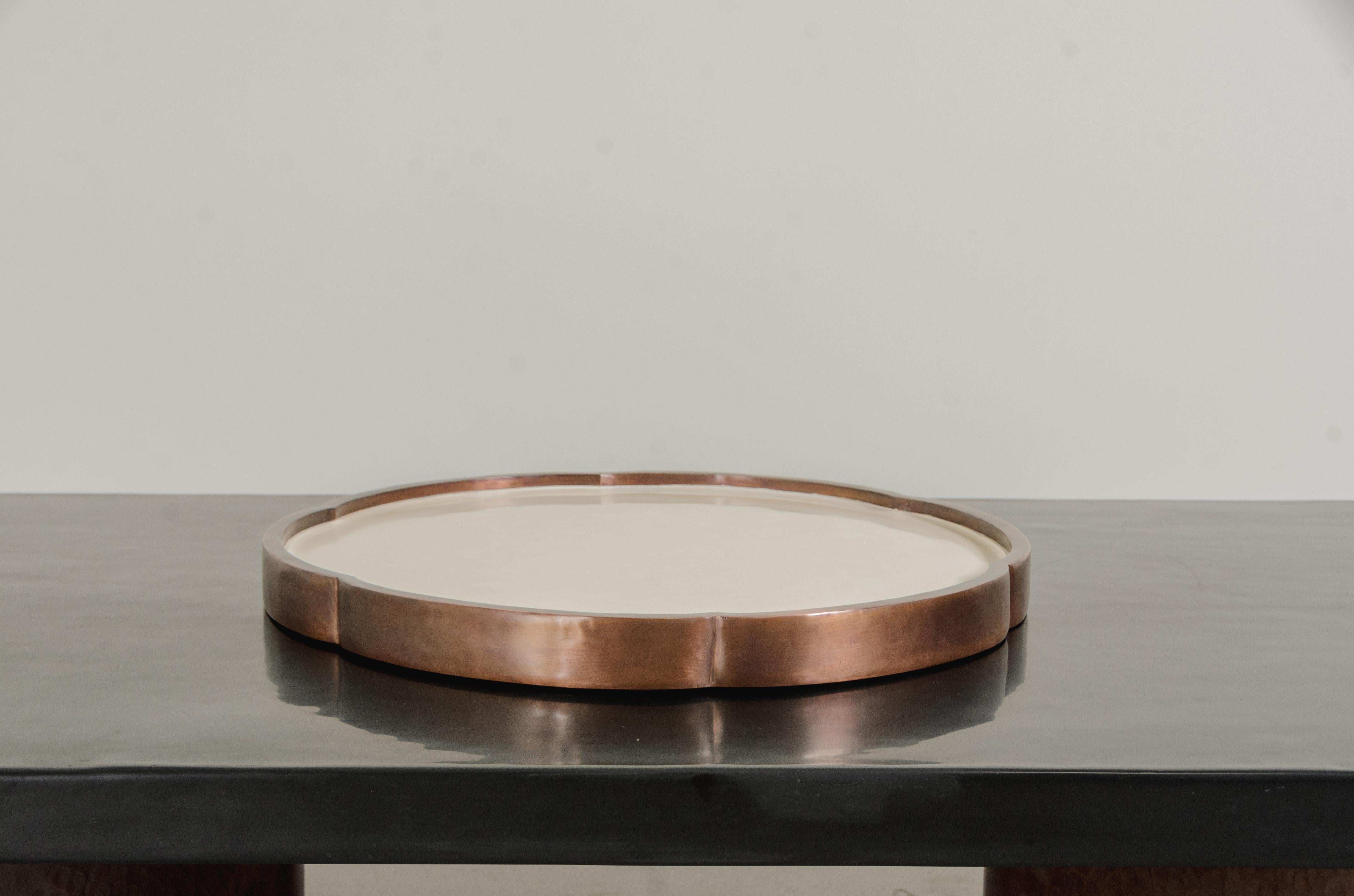 Vassoio a sei petali
Rame anticato
Lacca crema
Mano Repoussé
Edizione limitata
Contemporaneo

Il repoussé è l'arte tradizionale di martellare a mano rilievi decorativi sulla lamiera. Questa tecnica prevede l'utilizzo di un martello e di vari