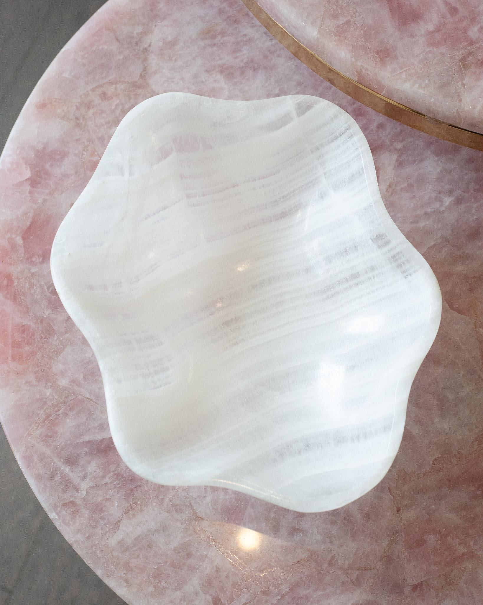 Invite the healing energy of onyx into your home with this remarkable, hand-carved mineral bowl. Crafted from a single piece of onyx, the bowl showcases banding in opaque and translucent white. Its polished finish gives the surface a refined