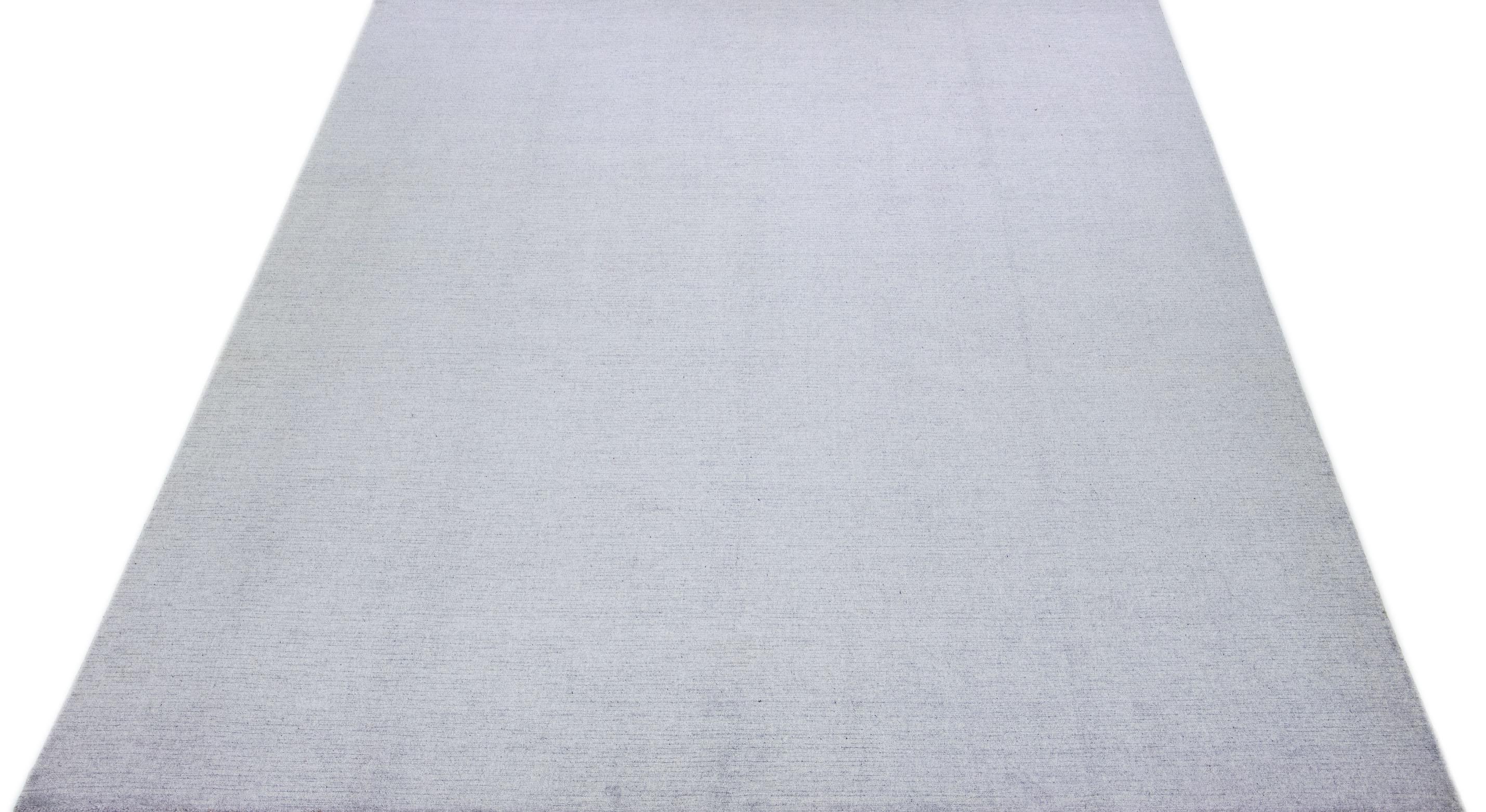 Cet exquis tapis contemporain en laine et soie présente une base gris-argent frappante ornée d'un étonnant motif géométrique qui s'étend gracieusement d'un bout à l'autre.

Ce tapis mesure 10'2