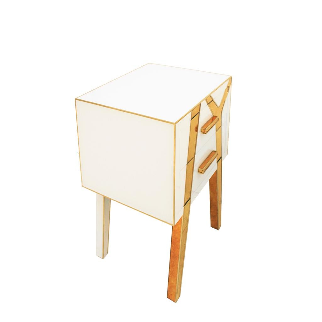 Un elegante par de mesillas de noche diseñadas y fabricadas por L.A. Studio Interiorismo. Estructura de madera maciza revestida de cristal blanco y dorado con detalles de latón. Compuesto por dos cajones y patas asimétricas.
Cristal de color dorado