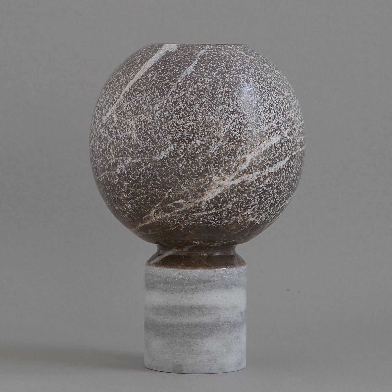 This minimalistic vase's spheric top is made from grey marble, and its base is made from dolomite. Both materials are sourced from a family-owned quarry in southern Turkey. The simplicity of form, pureness of the natural material and beauty of