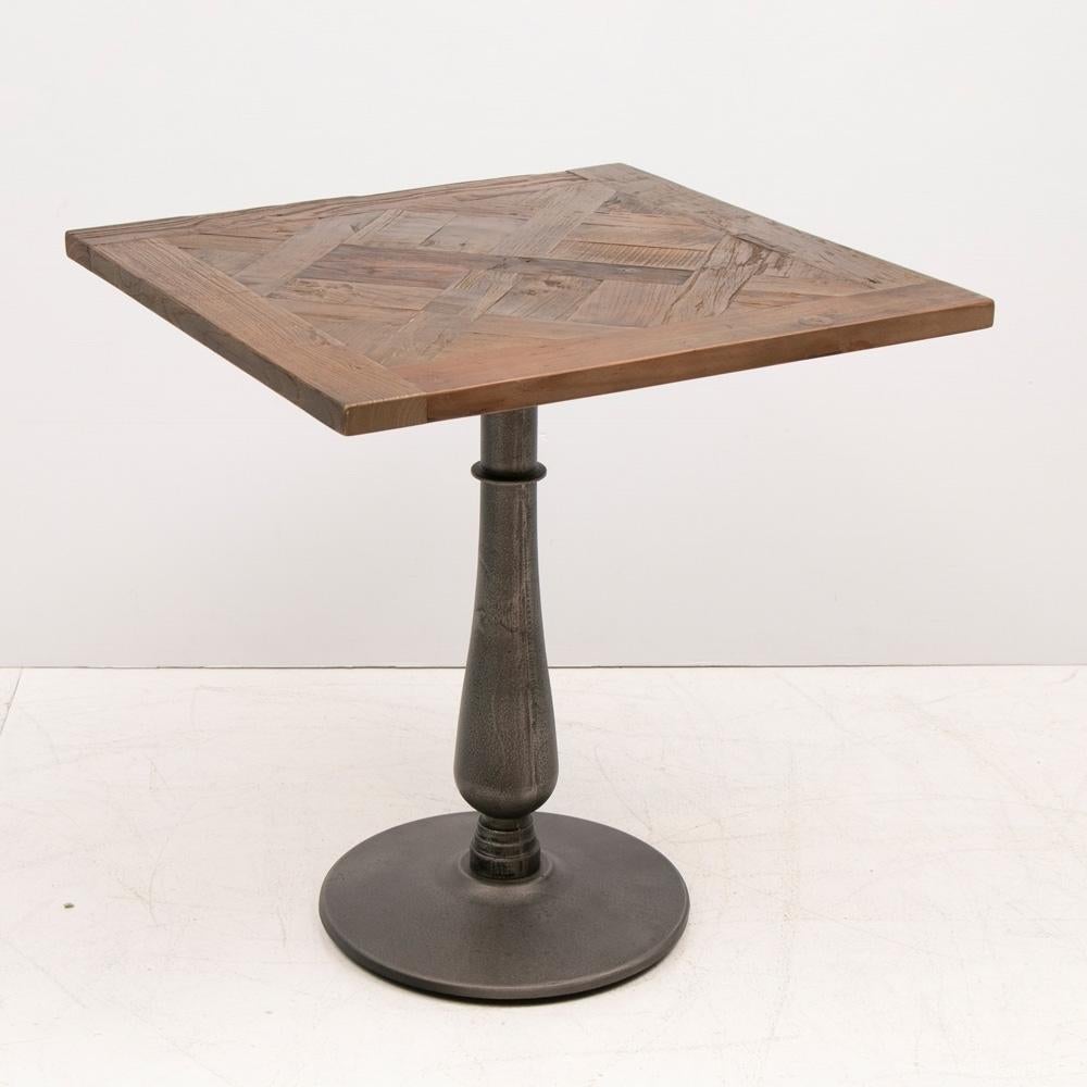 Contemporary wooden square top cafe table with metal pillar base.