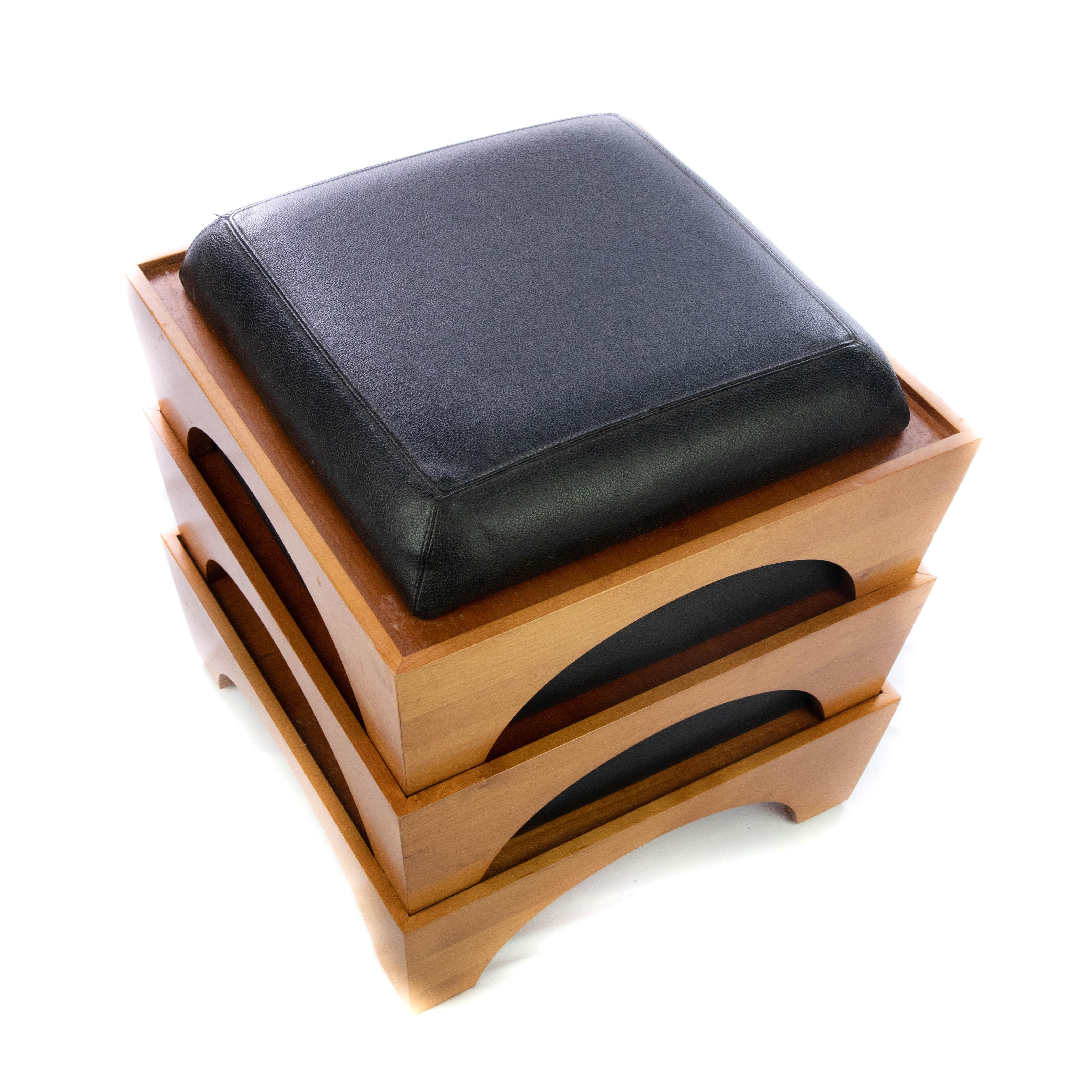 Offering these simplistic stackable foot stools made for Levenger. There are three in the set. The sides are of a light blended wood that have arches cut on each side that makes a bracketed foot. Each of them having a lip where the others can stack