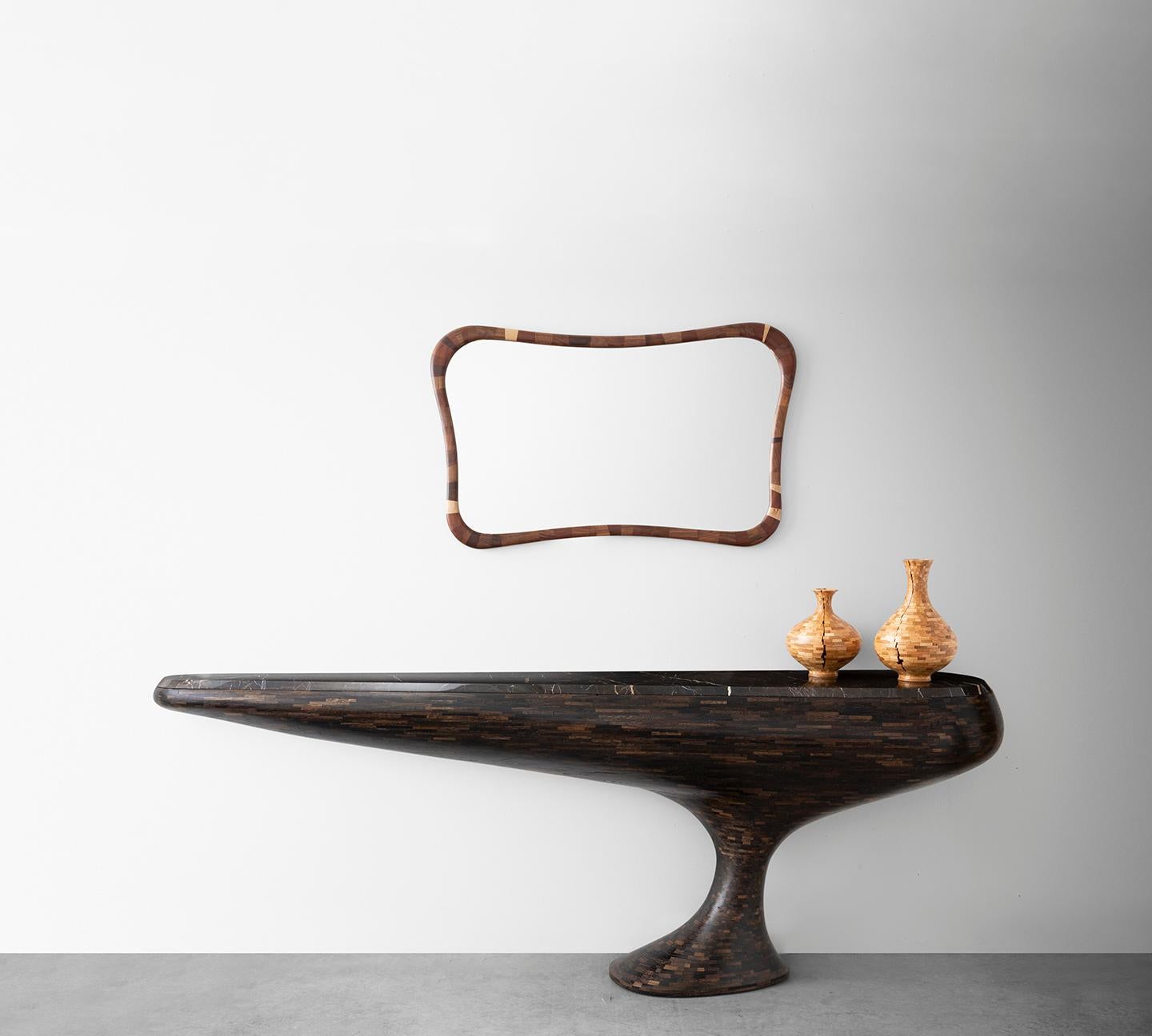 Part of Richard Haining's Stacked collection, this Console Table has a stance similar to a grand “hood ornament” from a classic car with it’s elongated but balanced symmetry solidly perched on a single foot. The thousands of tiny blocks of wood were