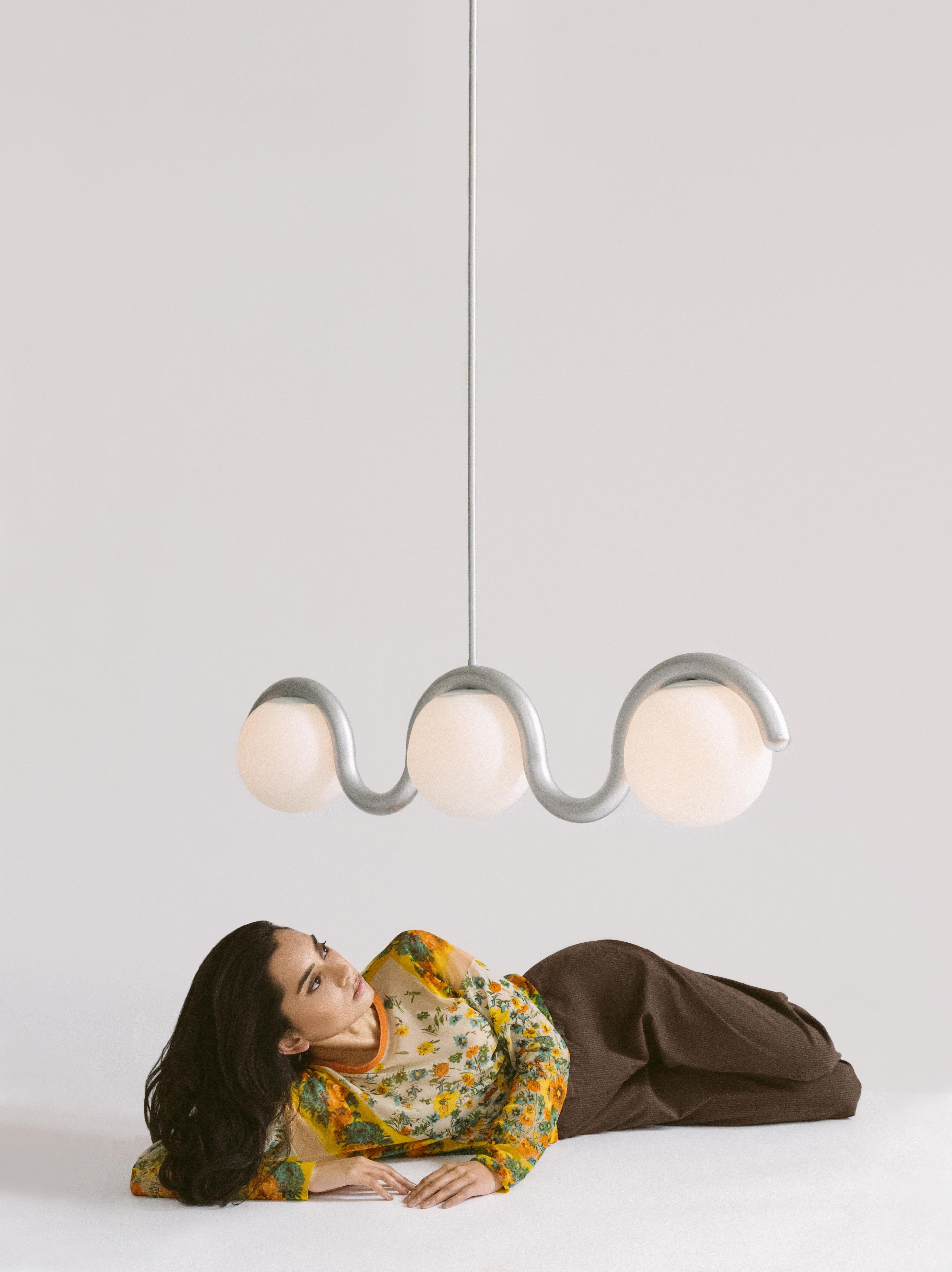 The scalloped design of the Lenox series was inspired by walks through Greenwich Village. A sophisticated and modern take on Art Nouveau, the metal tube bends around the shape of the globe light, creating a flow of movement and synchrony between the