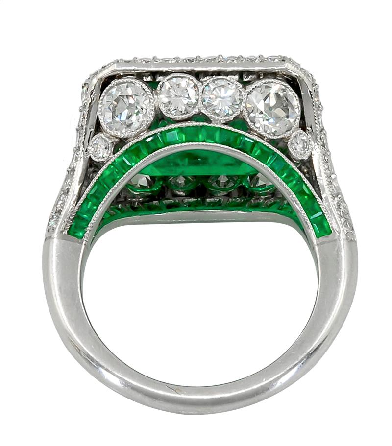 Contemporary Step Cut Emerald Diamond Ring 9.68 cts in Platinum.

A long step-cut emerald set in the east-west direction, with a diamond pavé demi-halo. The ring’s side details feature embedded white round diamonds, along with a bridge of tiny