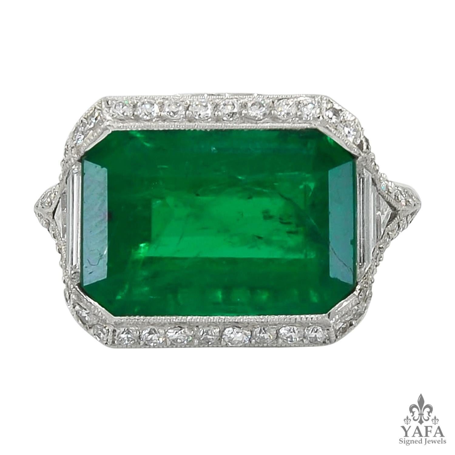 A long step-cut emerald set in the east-west direction, with a diamond pavé demi-halo. The ring's side details feature embedded white round diamonds, along with a bridge of tiny calibré-cut emeralds set in arc form.
Emerald weight approx. 9.68