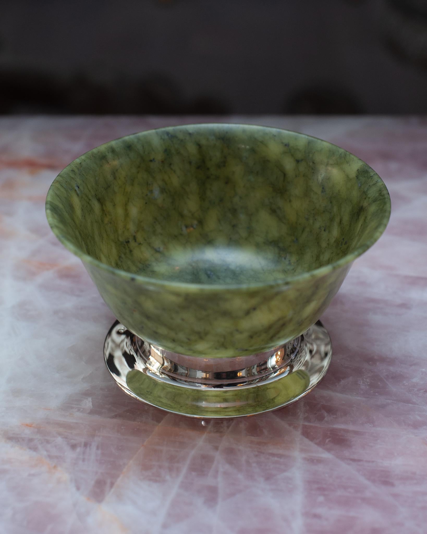 This stunning fine jade bowl is a true masterpiece, expertly crafted with remarkable attention to detail. The jade is of exceptional quality, with its serene green tones exuding a sense of tranquility and elegance. The natural variations in the jade