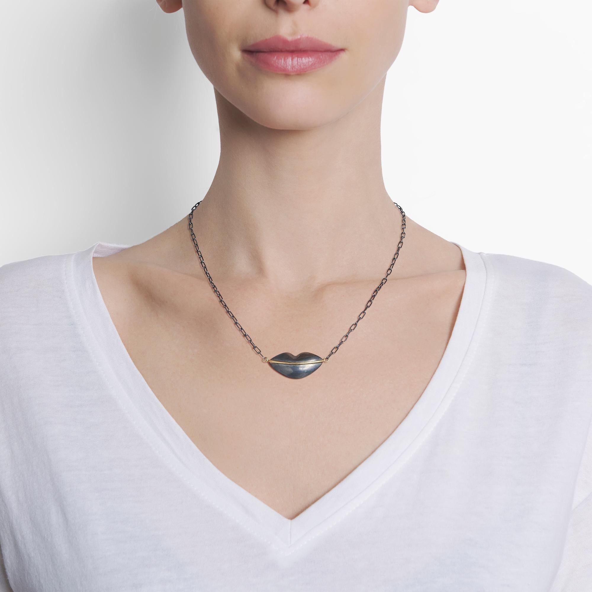 With a gentle smile, this one of a kind oxidized Sterling silver lips pendant with 22 karat gold will charm you.  It measures 1.25 inches in width, .32 inches in depth and approximately 17.5 inches in length.   The oxidized Sterling silver chain is