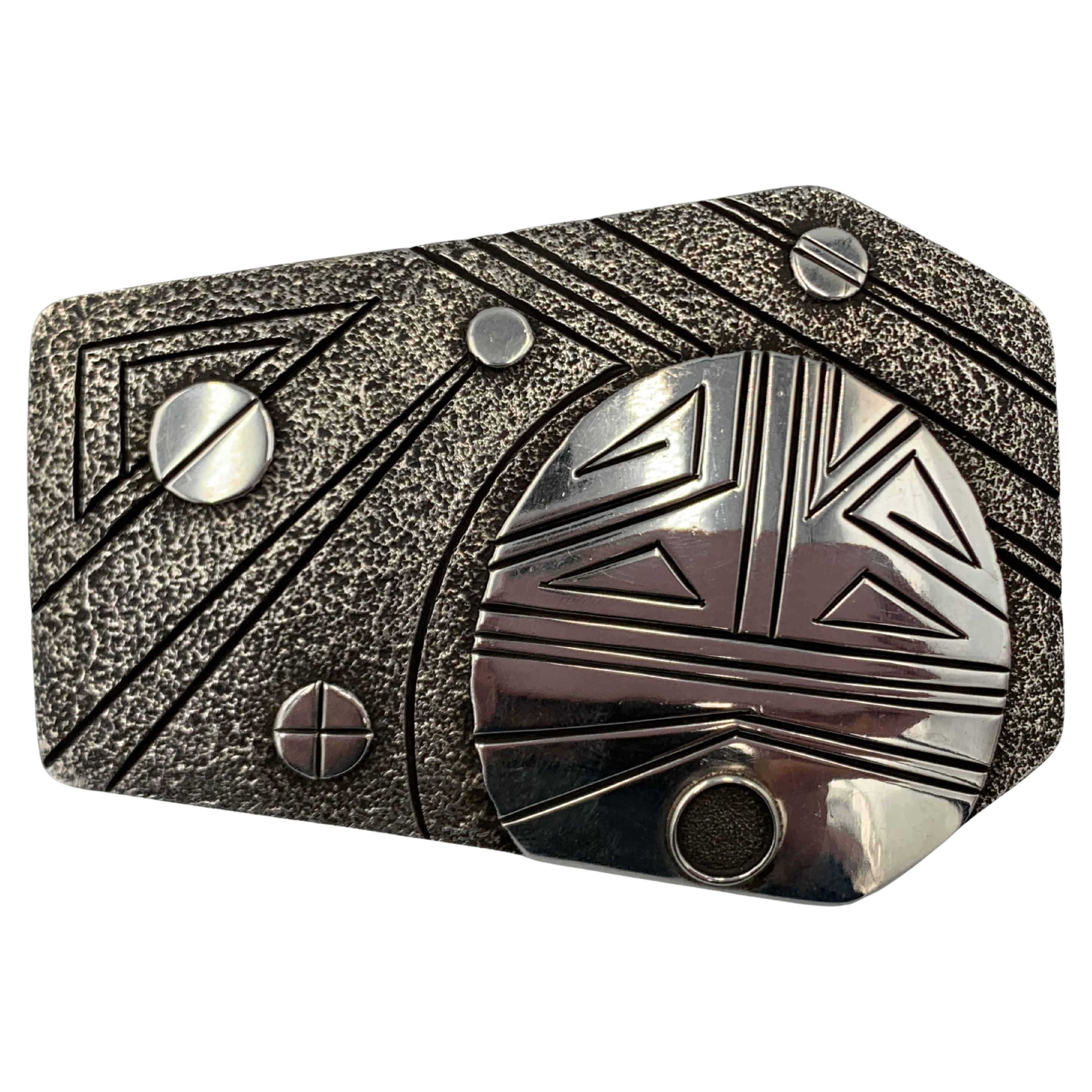 Hebilla de plata de ley fundida en tufo, obra del orfebre navajo Fidel Bahe. La hebilla contemporánea de 3,5