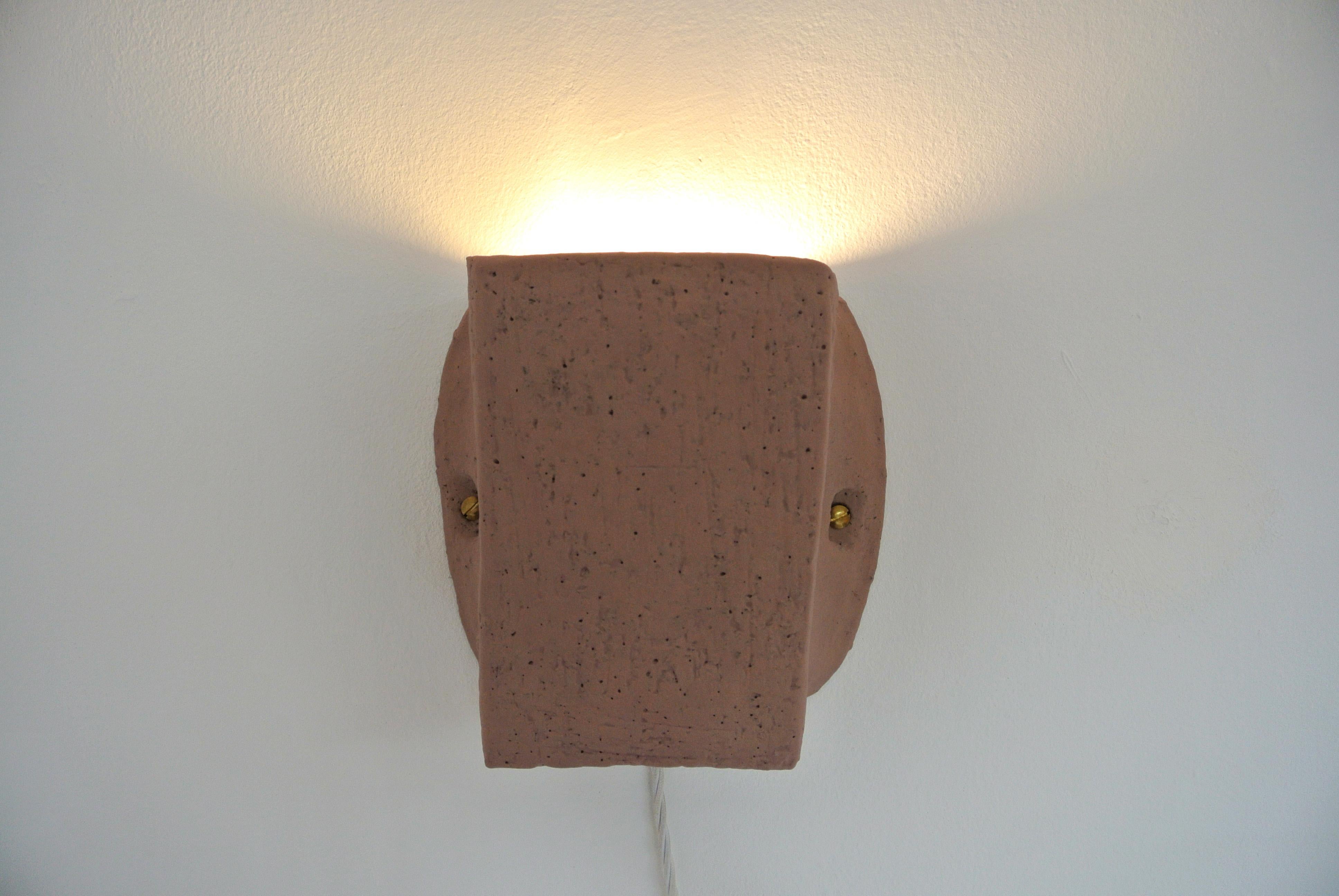 Contemporary, unique hand -build grey stoneware wall sconce with fire sand texture and pale pink Engobe by Danish Artist Christine Roland.


  