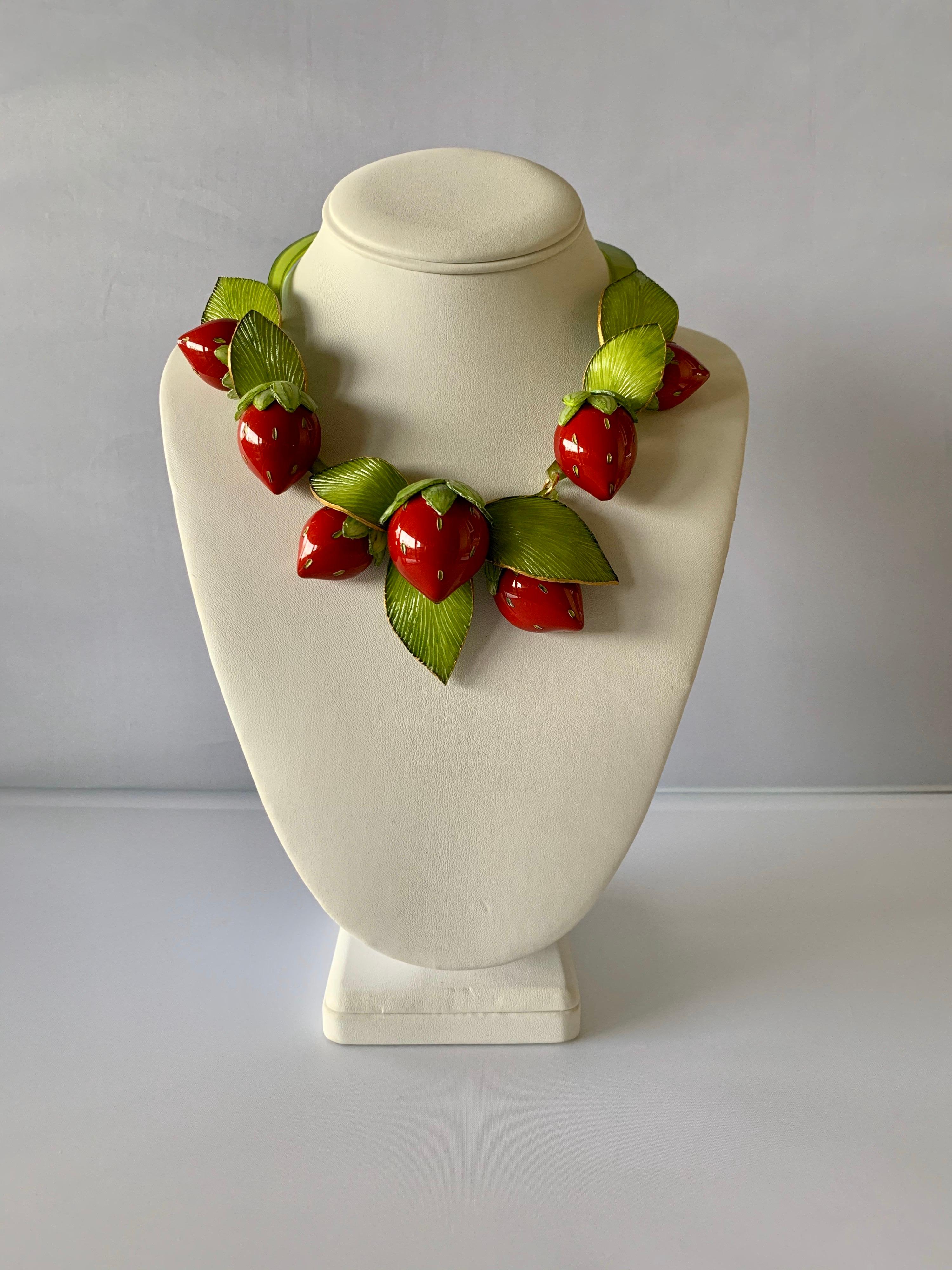 Light and easy to wear, the contemporary handmade adjustable artisanal necklace was made in Paris by Cilea. The statement necklace features seven red enameline (enamel and resin composite) strawberries. The strawberries differ size and feature