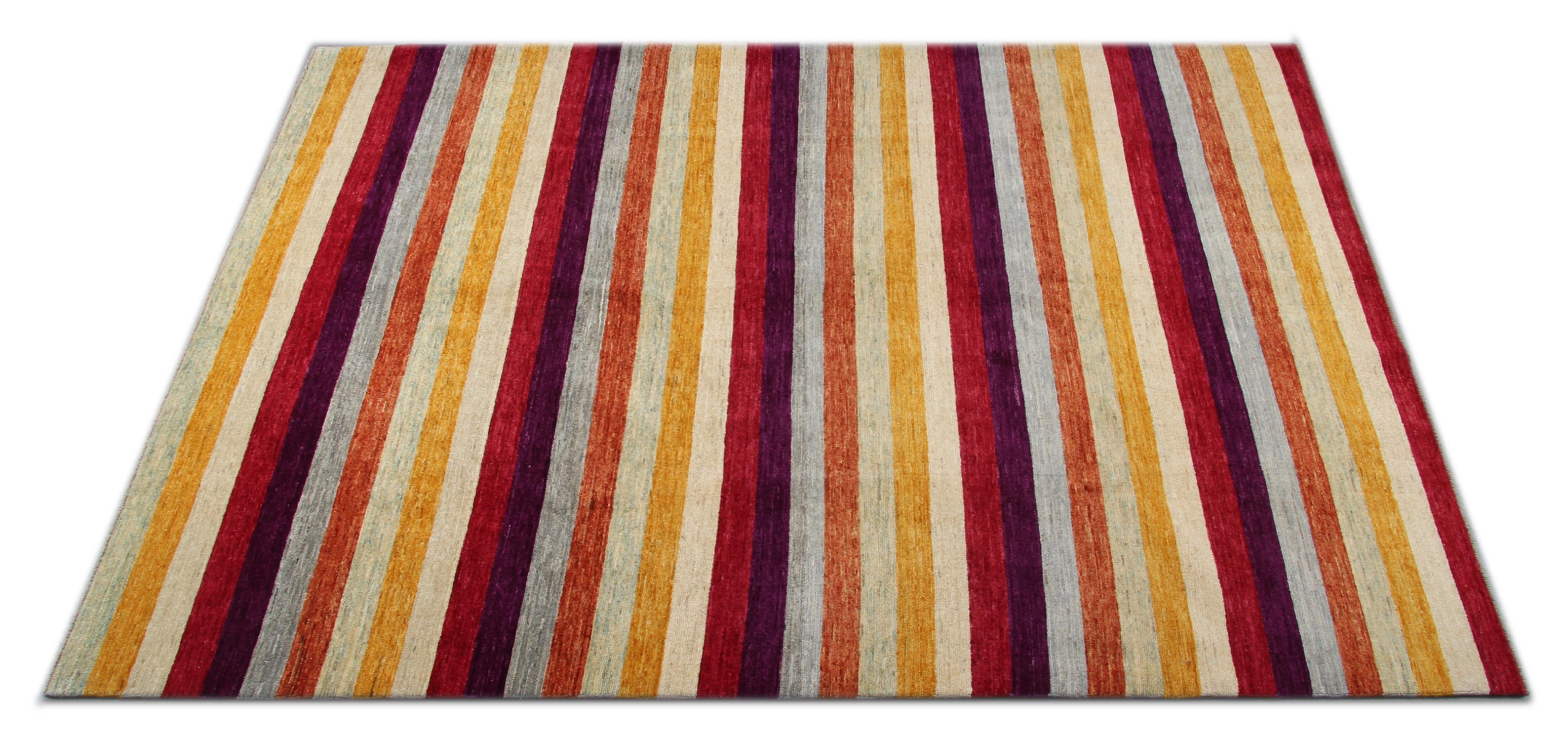 This modern area rug was hand knotted in India, the rug is a low pile carpet. Constructed with handspun wool featuring multicolored stripes of orange, yellow, grey and green. The contemporary design is perfect for both modern and traditional