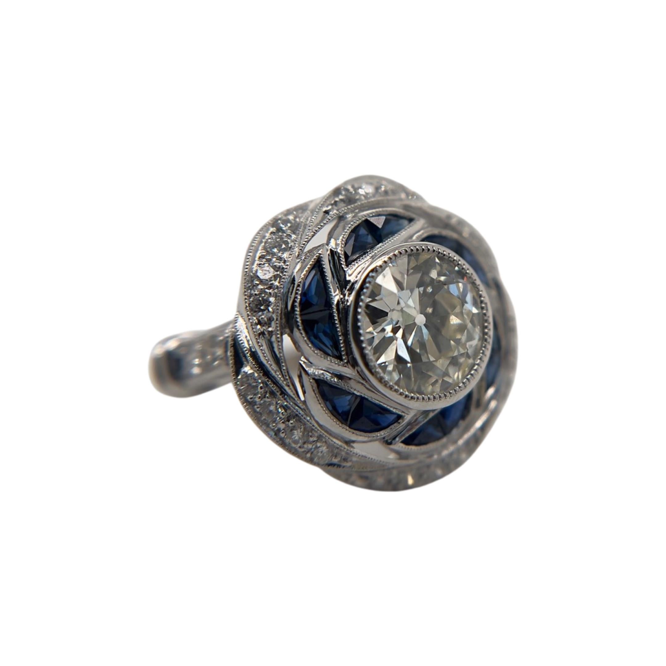 This enchanting contemporary style ring features a 2.06-carat Old European cut diamond. Set in 18-karat white gold and adorned with radiant sapphires, this enchanting piece exudes timeless charm. 





The center diamond, graded M Color VS1 Clarity