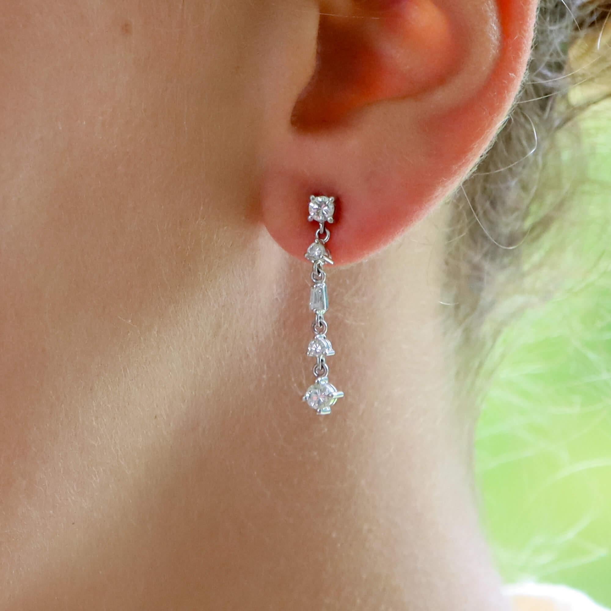 A beautiful pair of diamond drop earrings set in 14k white gold.

Each earring is composed of simple drop of 5 diamonds, all connected by an articulated bail. Each diamond is securely claw set and all hang elegantly from the ear.

There is a