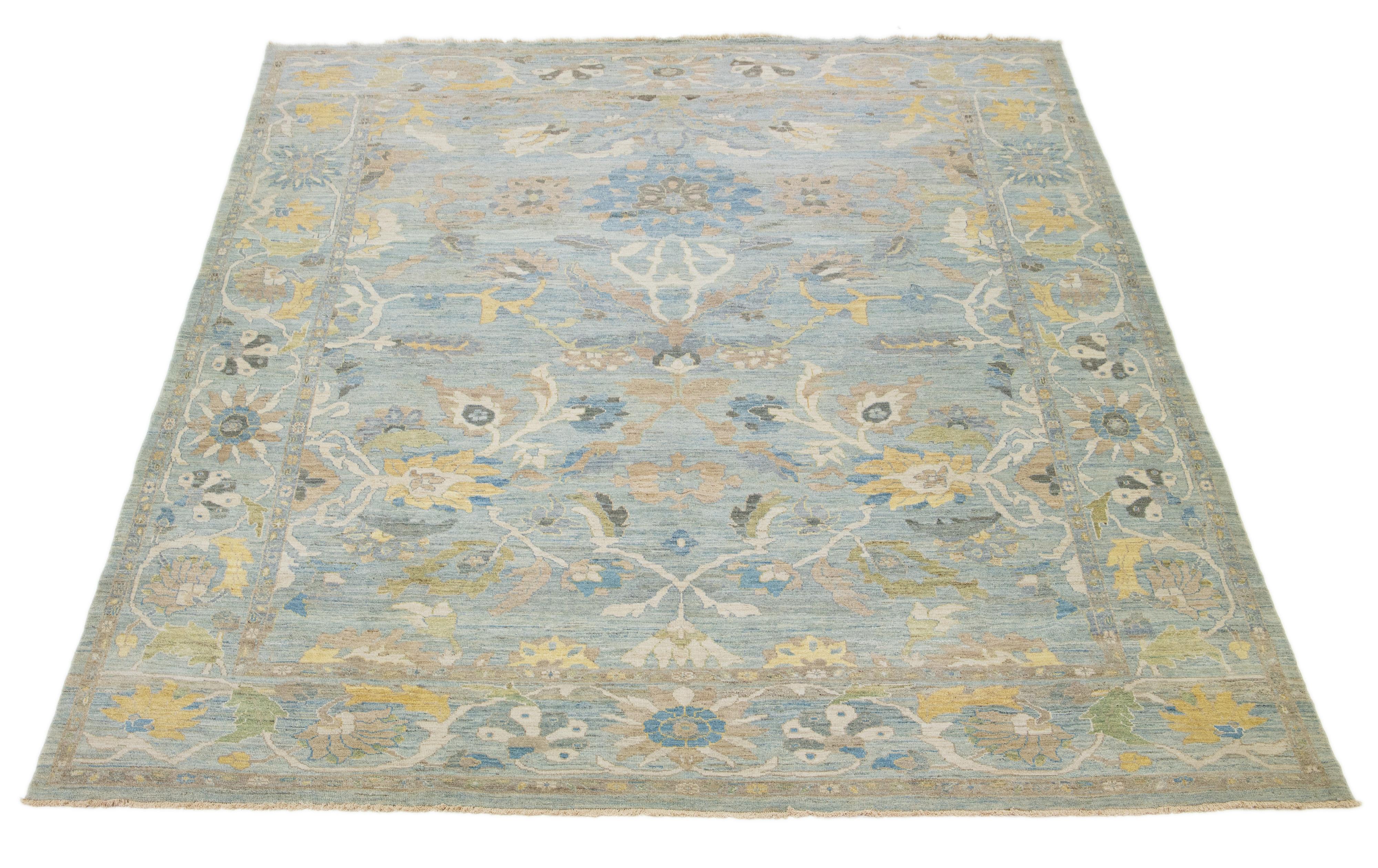 Dieser handgeknüpfte Wollteppich hat einen hellblauen Hintergrund, der mit gelben, beigen und braunen Allover-Motiven verziert ist.

Dieser Teppich misst 12'4'' x 14'10''.