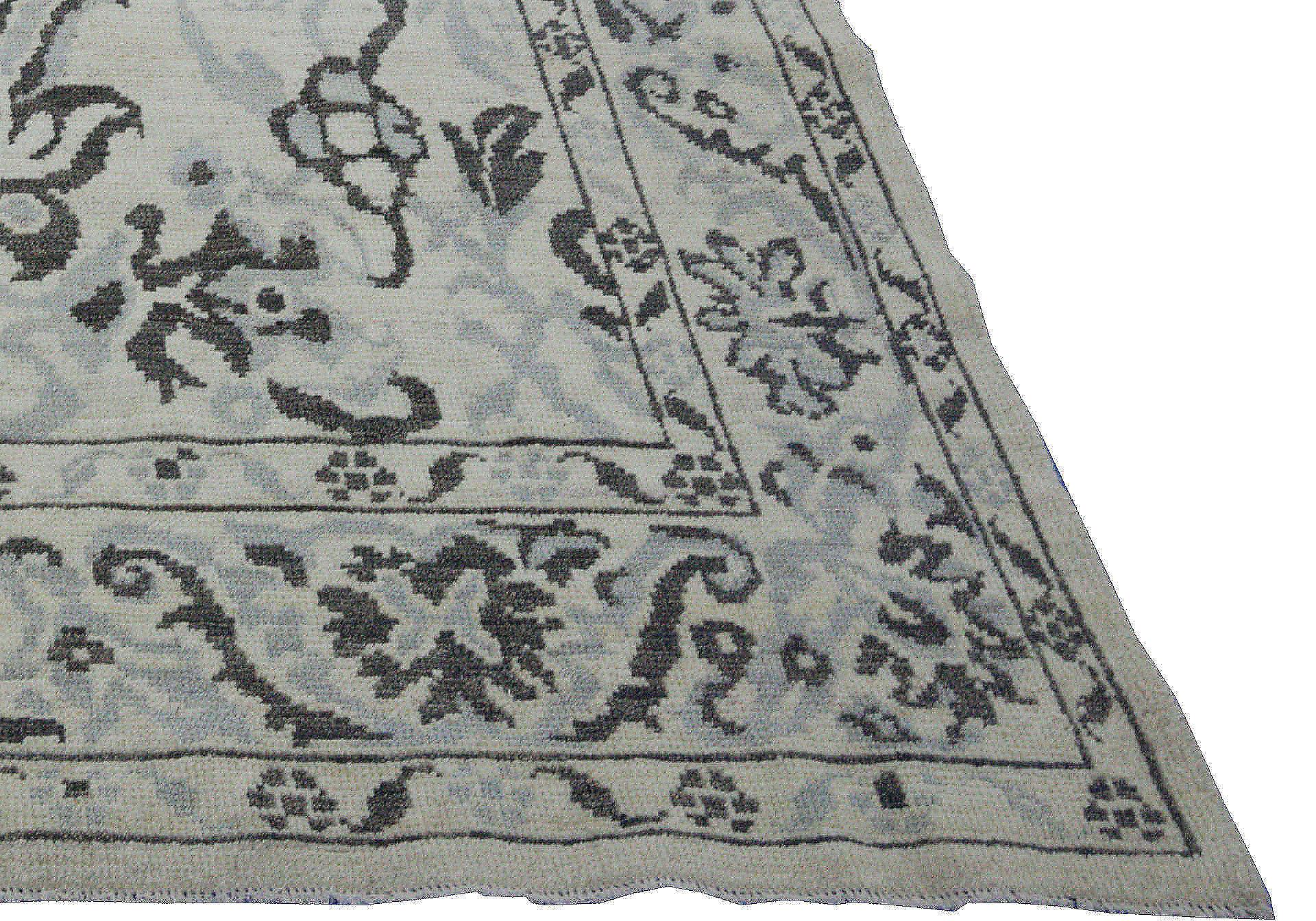 Contemporary Turkish rug made of handwoven sheep’s wool of the finest quality. It’s colored with organic vegetable dyes that are certified safe for humans and pets alike. It features an ivory field with black and gray floral patterns identified with