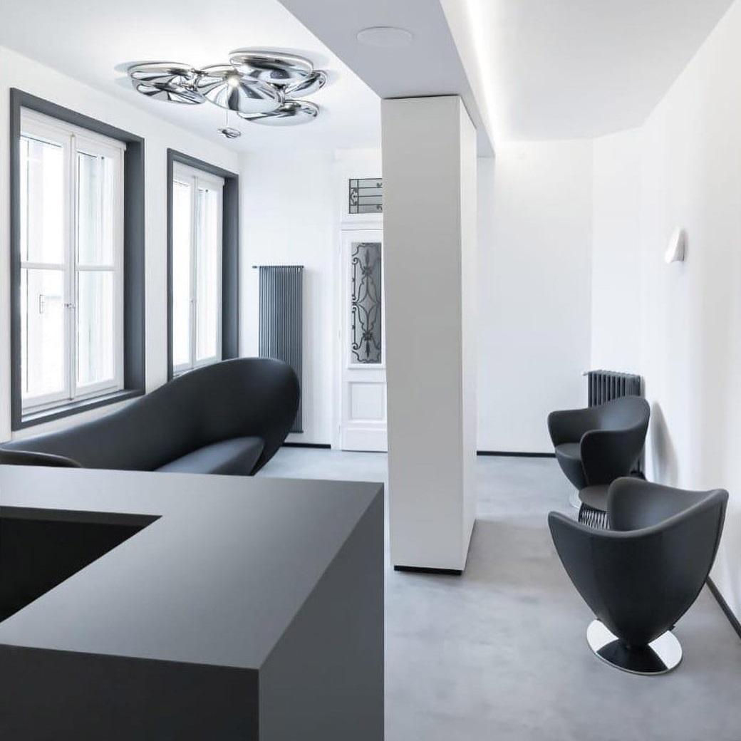 Italiano Poltrona girevole contemporanea con linee curve e base in metallo in vendita