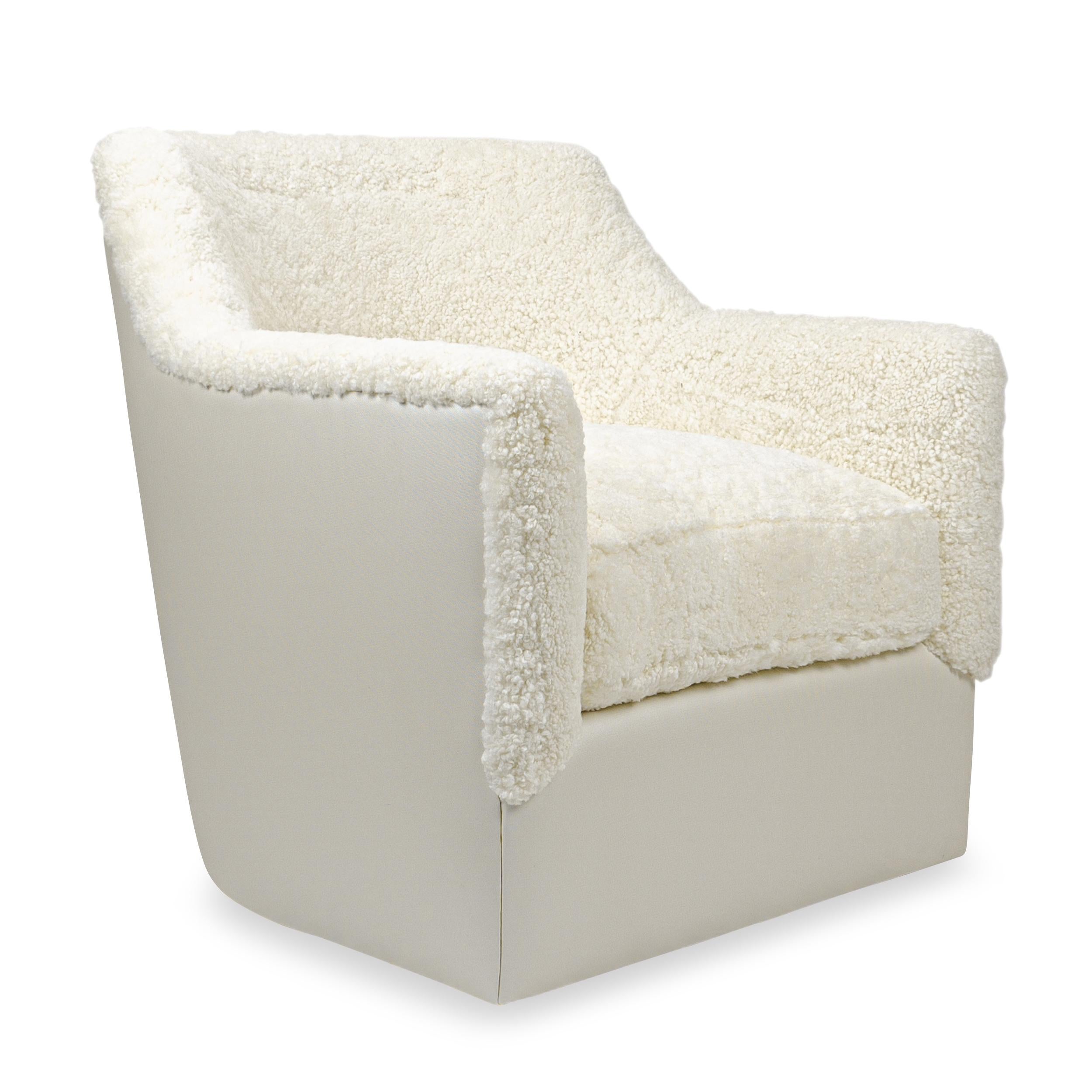 Le fauteuil pivotant Tyler est un modèle de fauteuil pivotant contemporain doté d'accoudoirs courbés vers l'arrière. L'assise à coussin lâche est fabriquée à la main avec de la mousse et une enveloppe de plumes de duvet pour une expérience d'assise