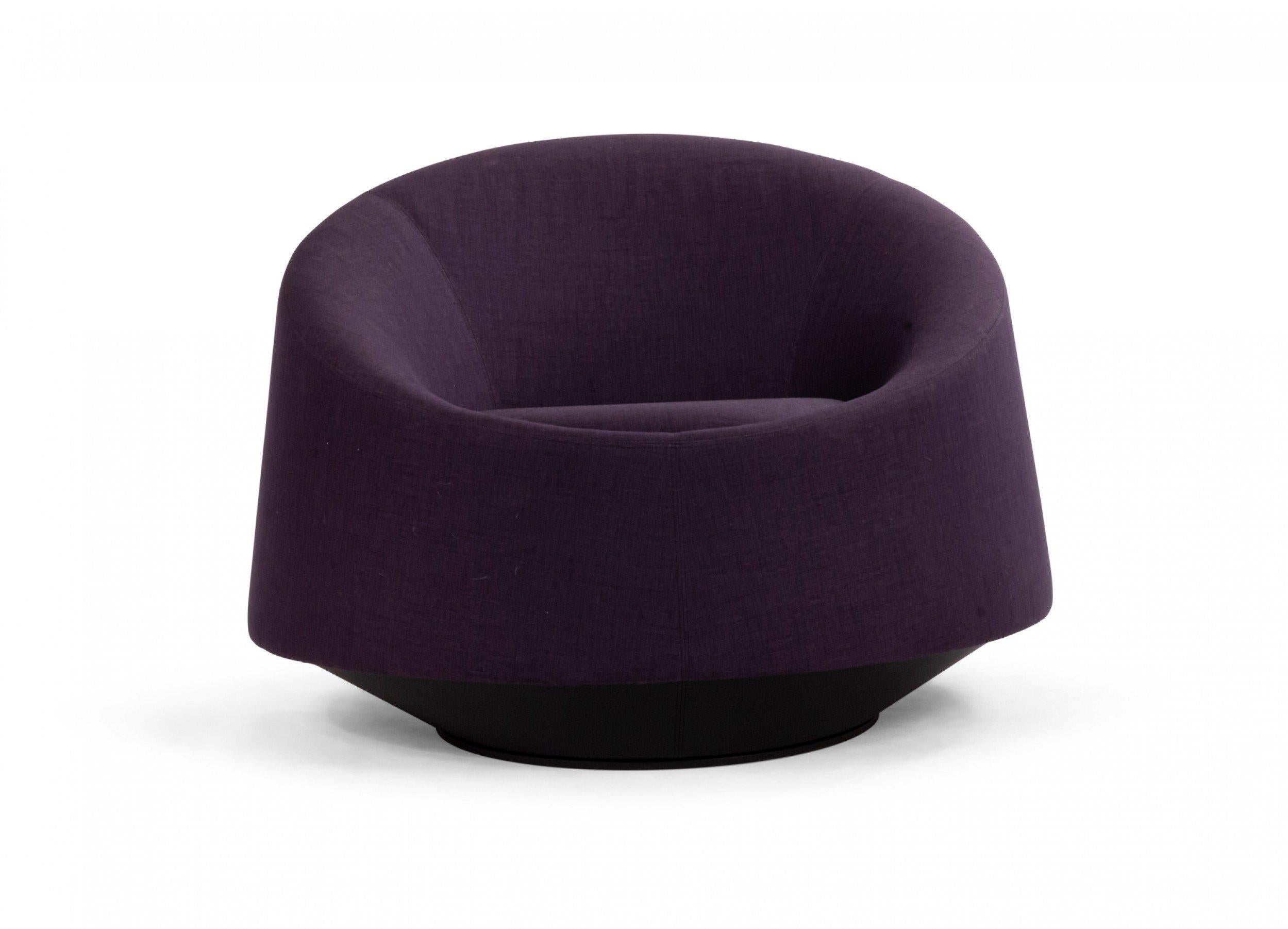 Contemporary swiveling circular shaped arm chair with deep purple fabric upholstery.
