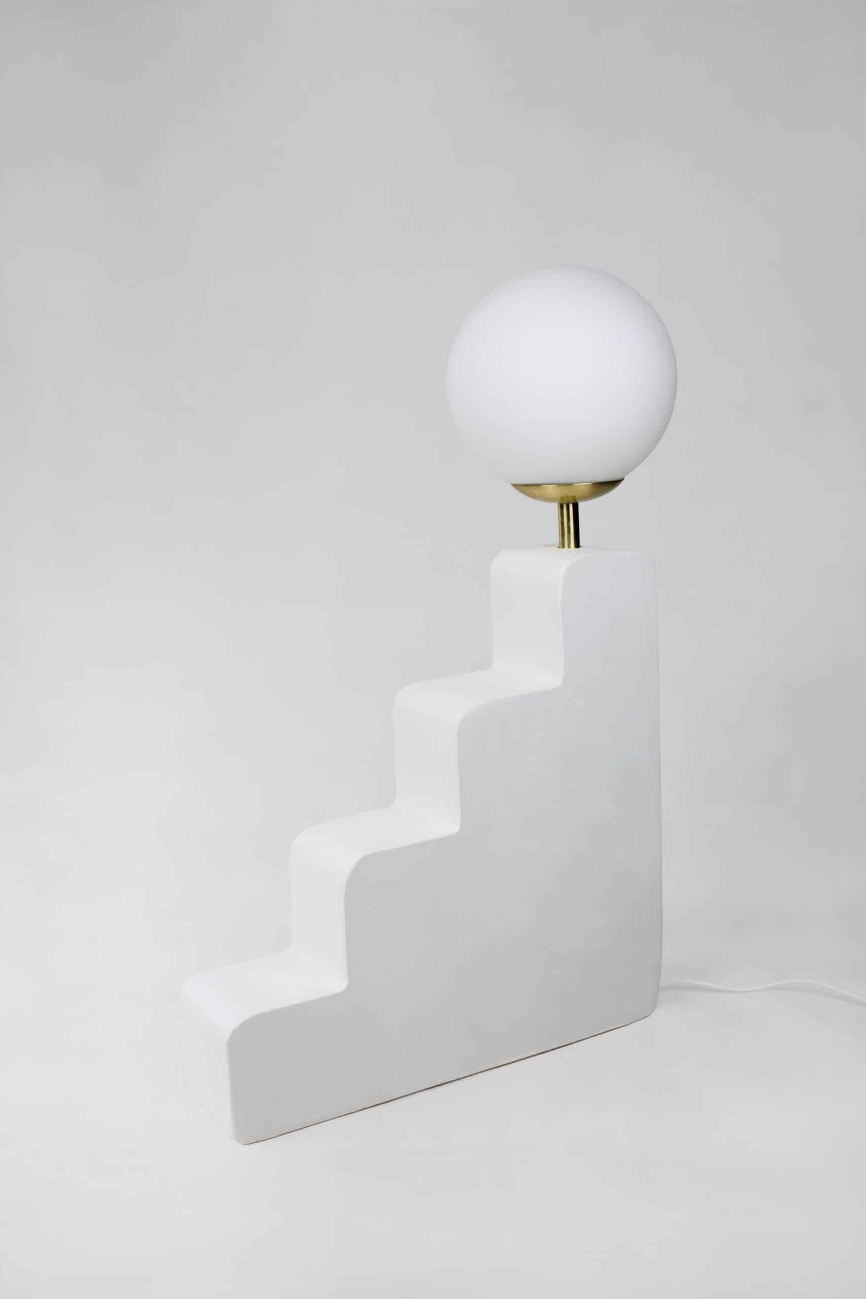 Big Step Lamp is a contemporary handmade lamp from the Forms Collection, made in gypsum. The sculpture’s form alludes to ambition and enlightenment in a playful way. The lamp’s smooth, organic curves invites the viewer to explore its surface with
