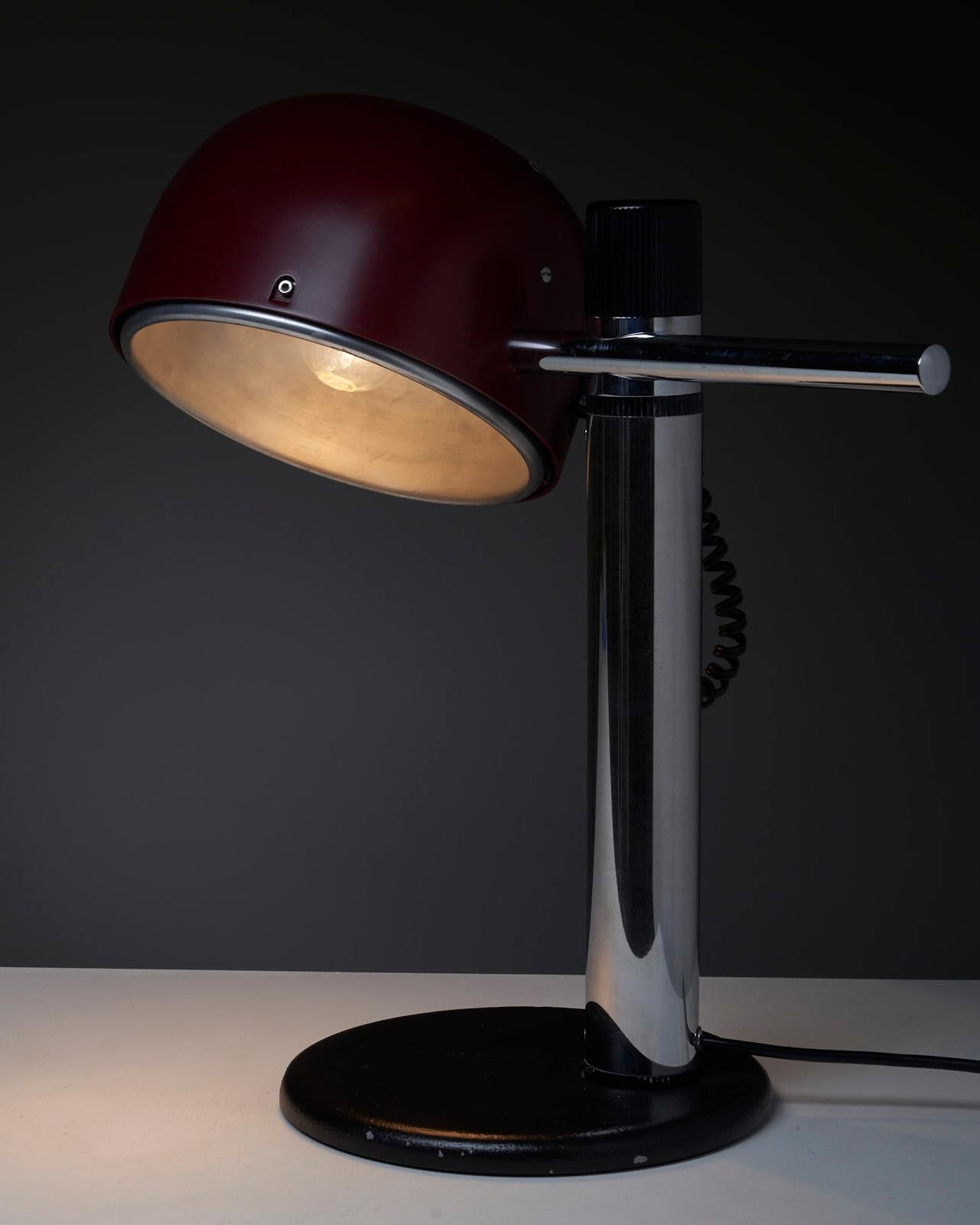 The moveable shade along the lamp holder adds flexibility and versatility to the lamp's positioning, and the reflective inner shade can help to create a focused and directed beam of light. The dark bordeaux color adds a touch of elegance and