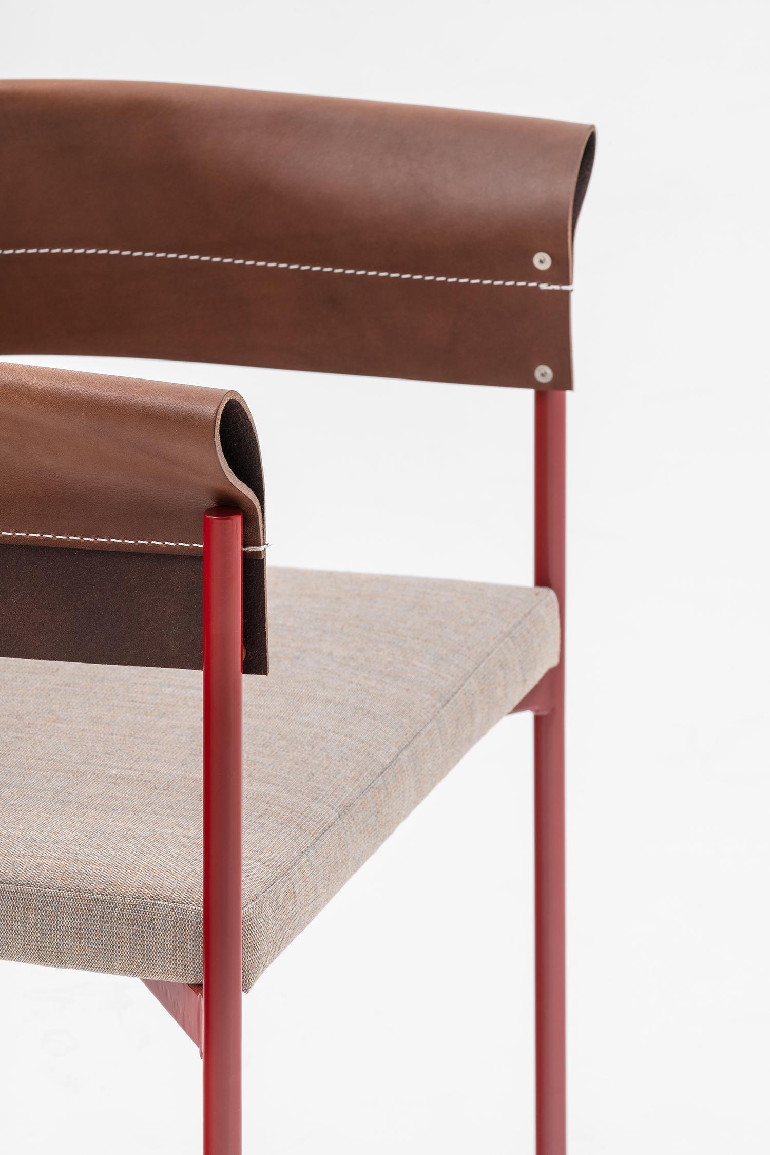 Lounge armchair made with a thin and elegant hand-welded steel frame whose curvature supports the precious leather, folded and sewn to act as a backrest and the same time as an armrest. Available in red, blue, black structure as per the full grain