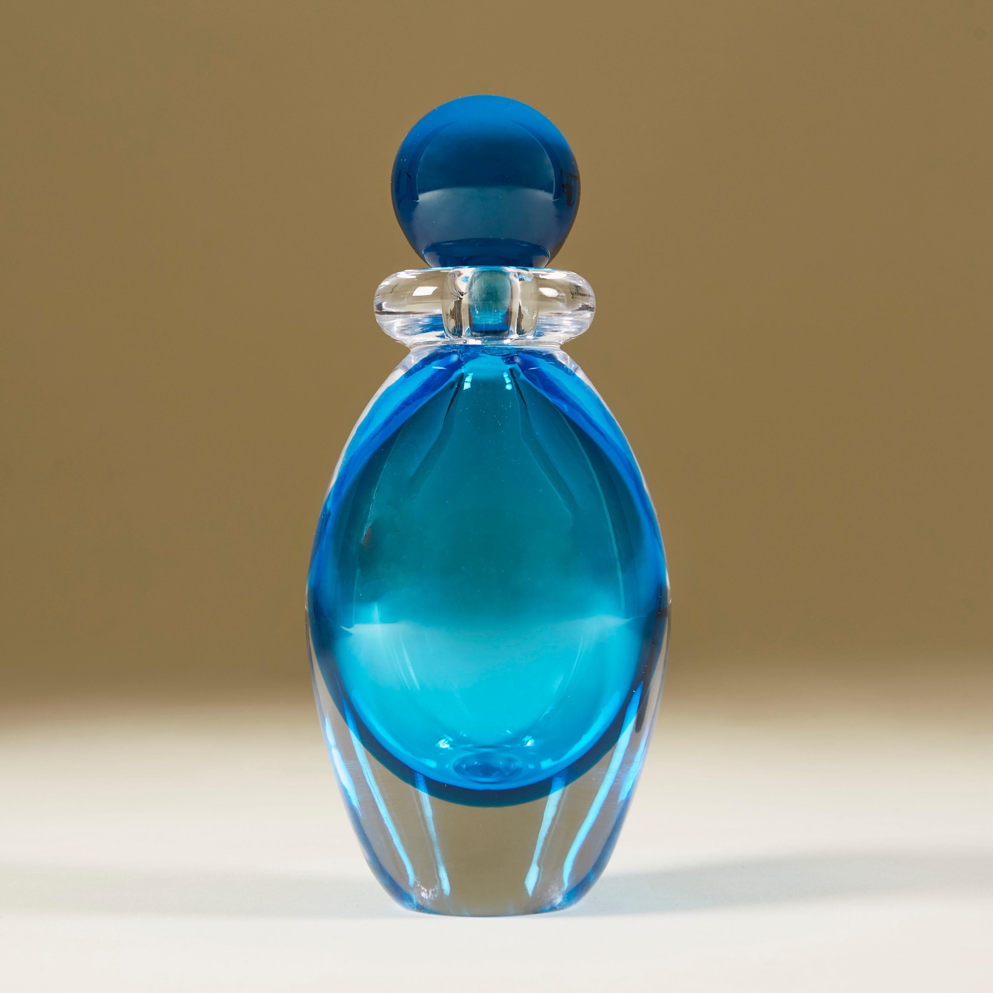 Rich aquamarine tall perfume bottle cased in clear Murano glass with clear glass collar and aqua marine ball stopper.
