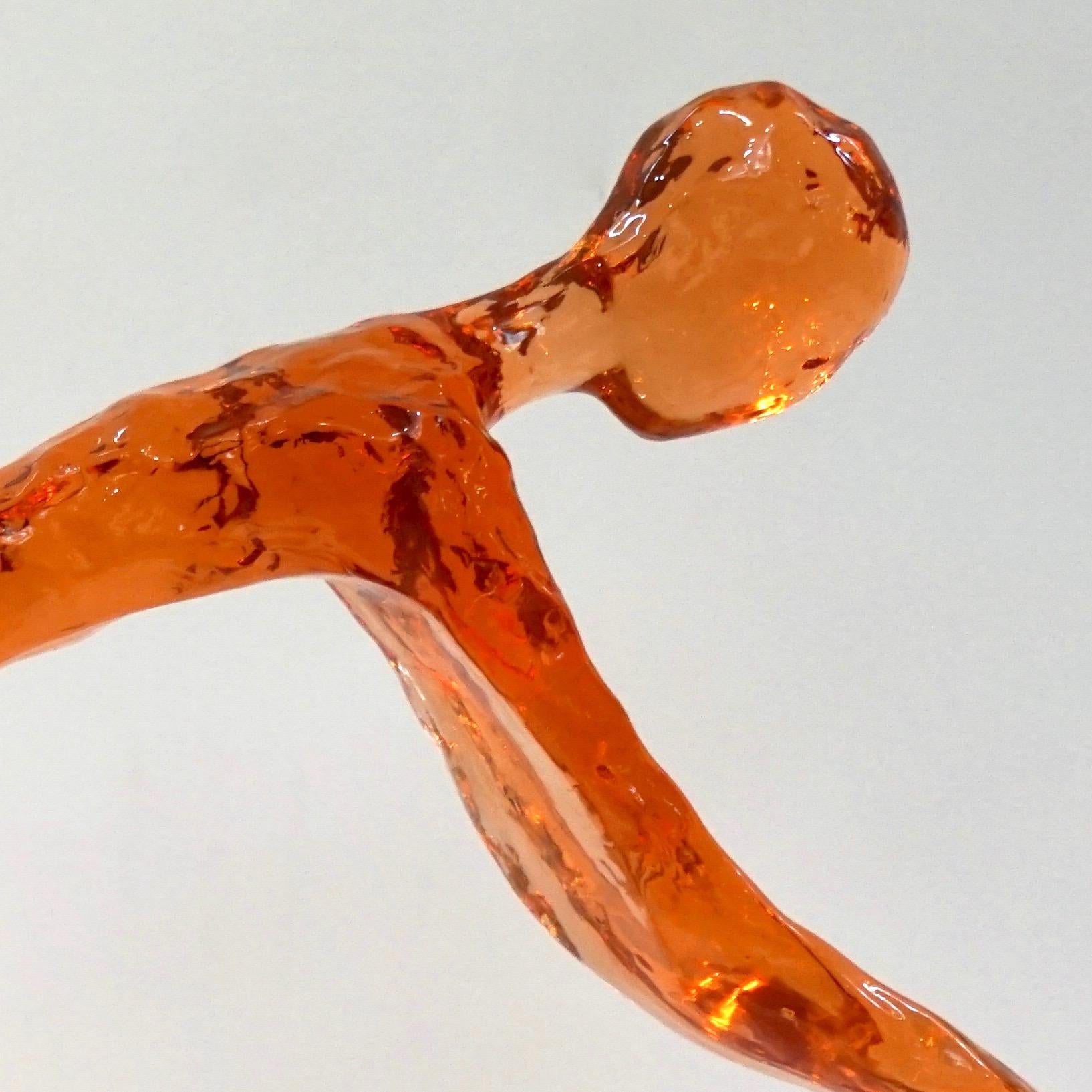 Organic Minimalist biker on a bicycle, made in the USA in high-quality lucent pastel orange color acrylic, with a sophisticated textured finish that makes it look like a glasswork of Art, exclusively handcrafted and curated by a small Art Studio