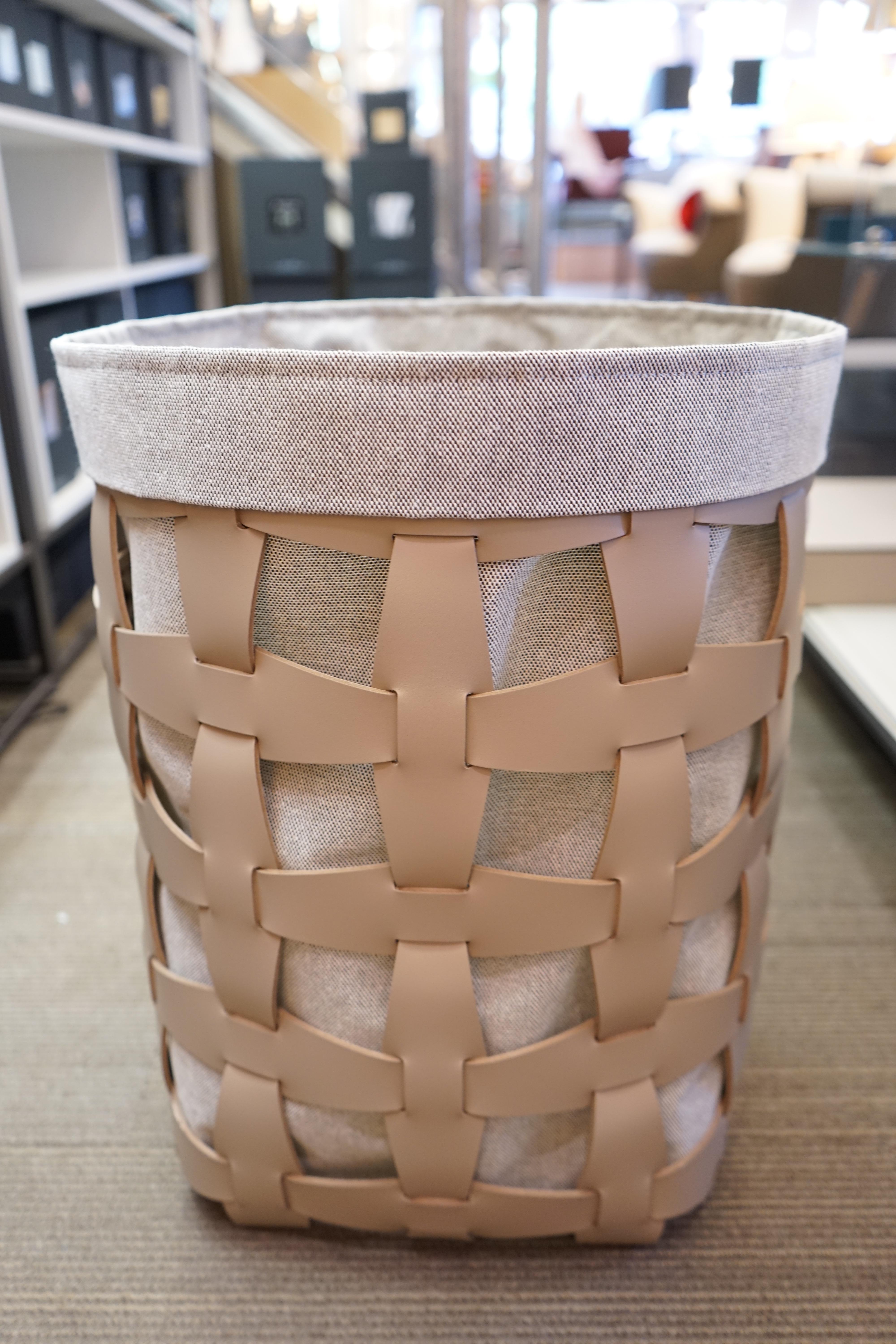 Contemporary taupe woven leather circular laundry basket by Pinetti. Handmade in Italy. A woven leather grid creates the framework for a canvas border and interior. Balancing contemporary elements with the timeless tradition of leather, the basket