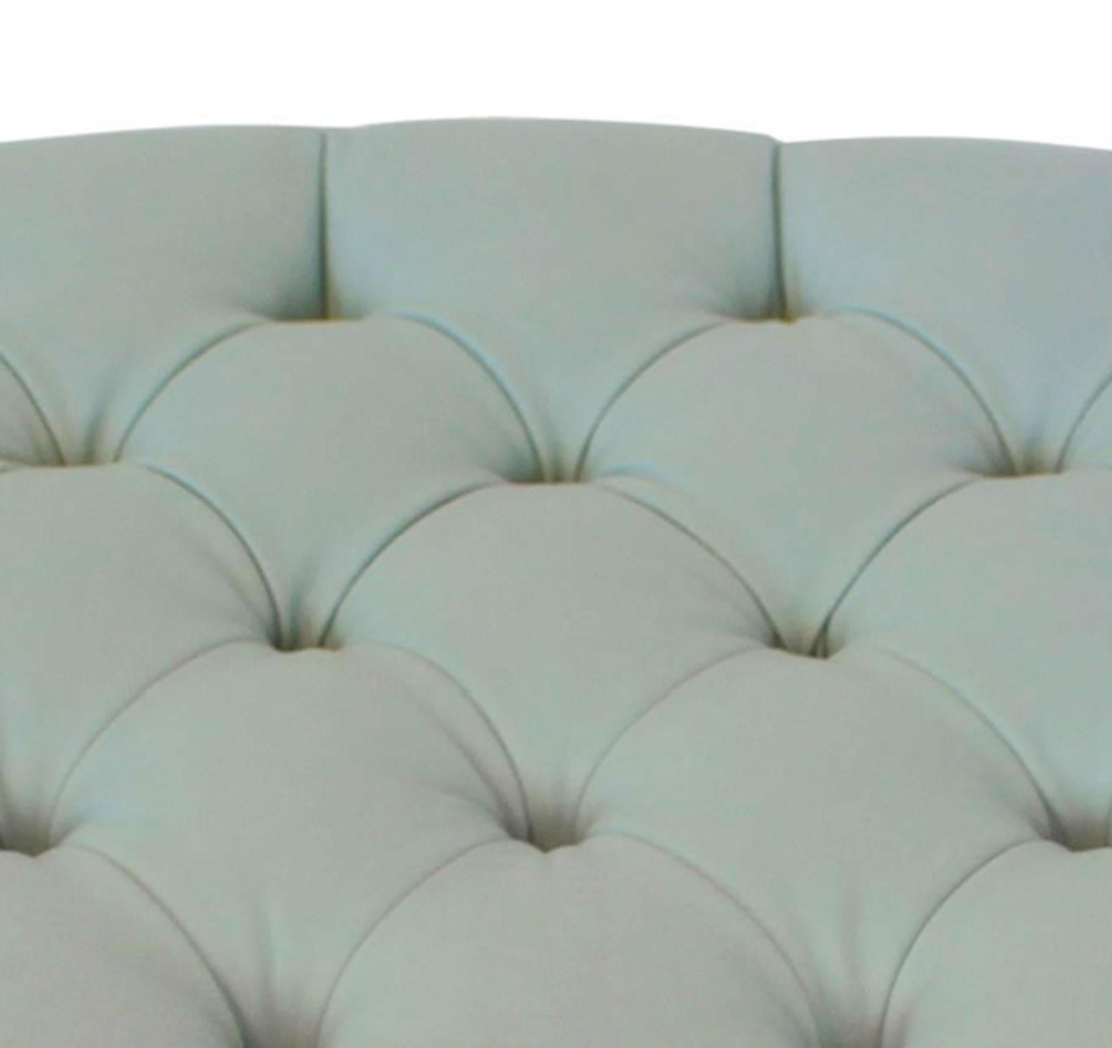 A contemporary teal leather tufted ottoman of oval shape with chrome frame from the 21st century. The oval seat is upholstered in teal-colored leather with button-tufting design and rests on a chrome frame. The metal oval rail is mounted on very