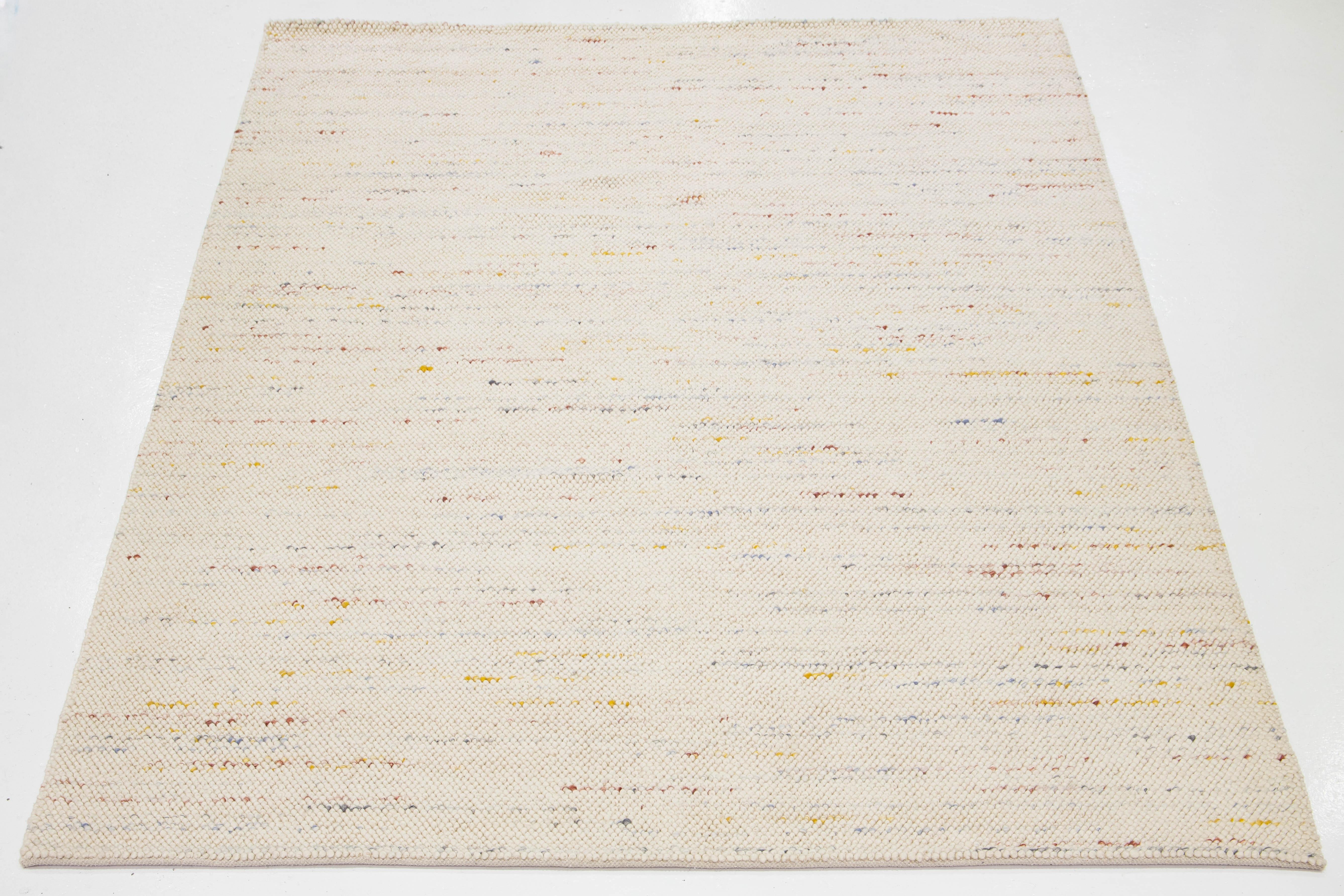 Questo moderno tappeto indiano in lana annodato a mano è stato abilmente tessuto da artigiani e presenta un design morbido e multicolore. La sua tonalità beige funge da sfondo versatile, consentendogli di integrarsi perfettamente con vari stili di