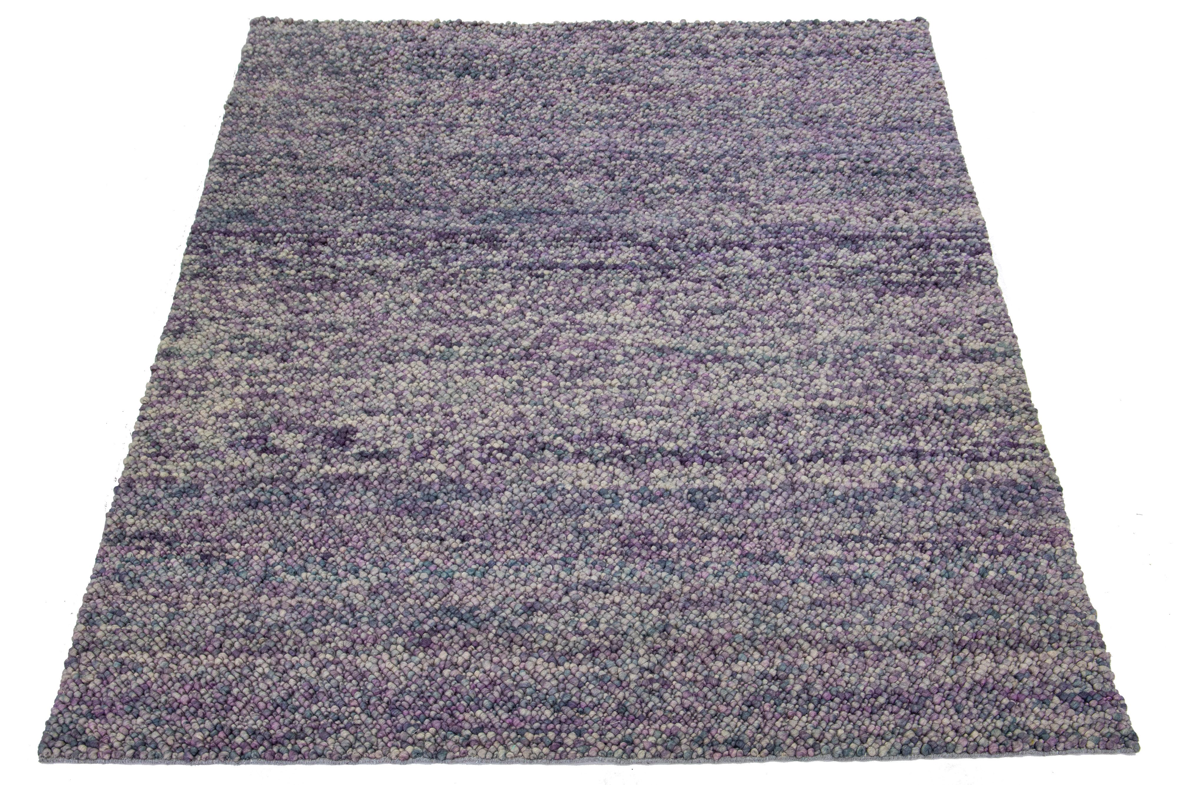 This beautiful, modern texture hand-knotted wool rug part of our Saco collection features a color field of purple, blue, and gray. The rug also boasts a stunning textured abstract design resembling pebbles.

This rug measures 8' x 11'.

Our rugs are