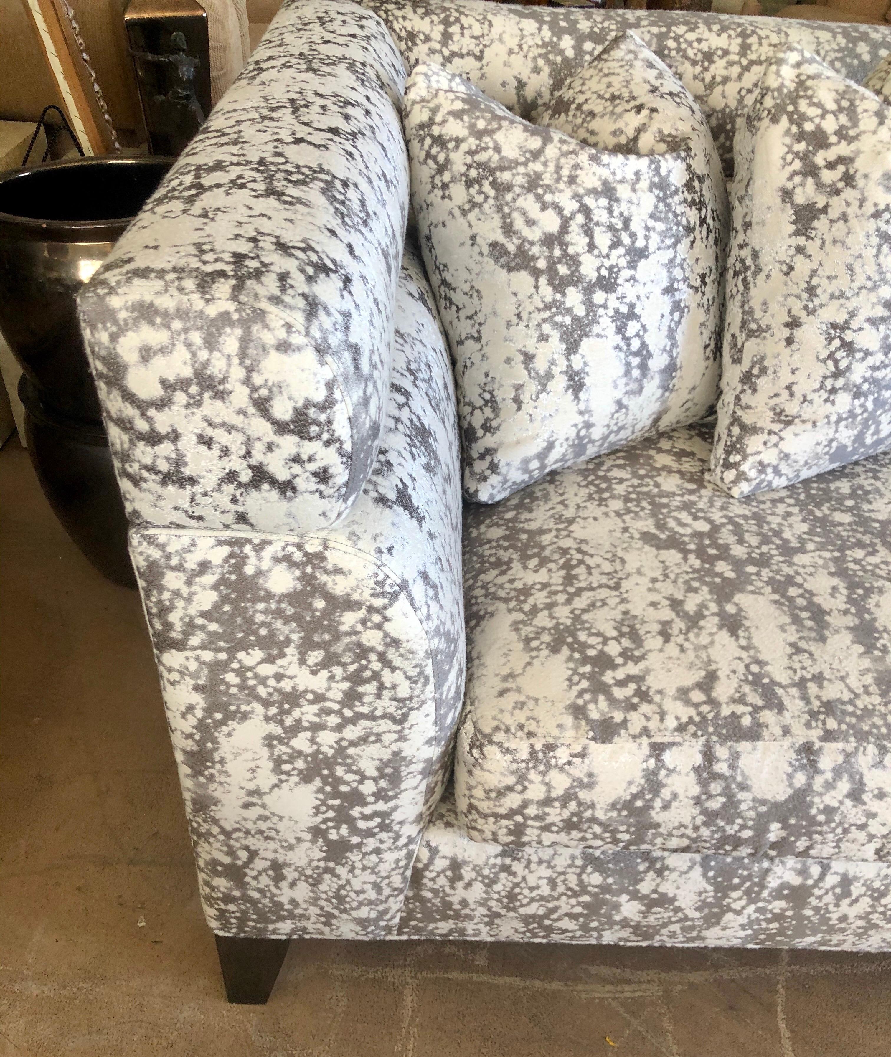 This beautiful contemporary sofa is less than six months old. It was custom ordered and made in the USA by high-end maker Theodore Alexander. The fabric is a modern Art abstract pattern that looks like it has metallic in it. A cross between a velour