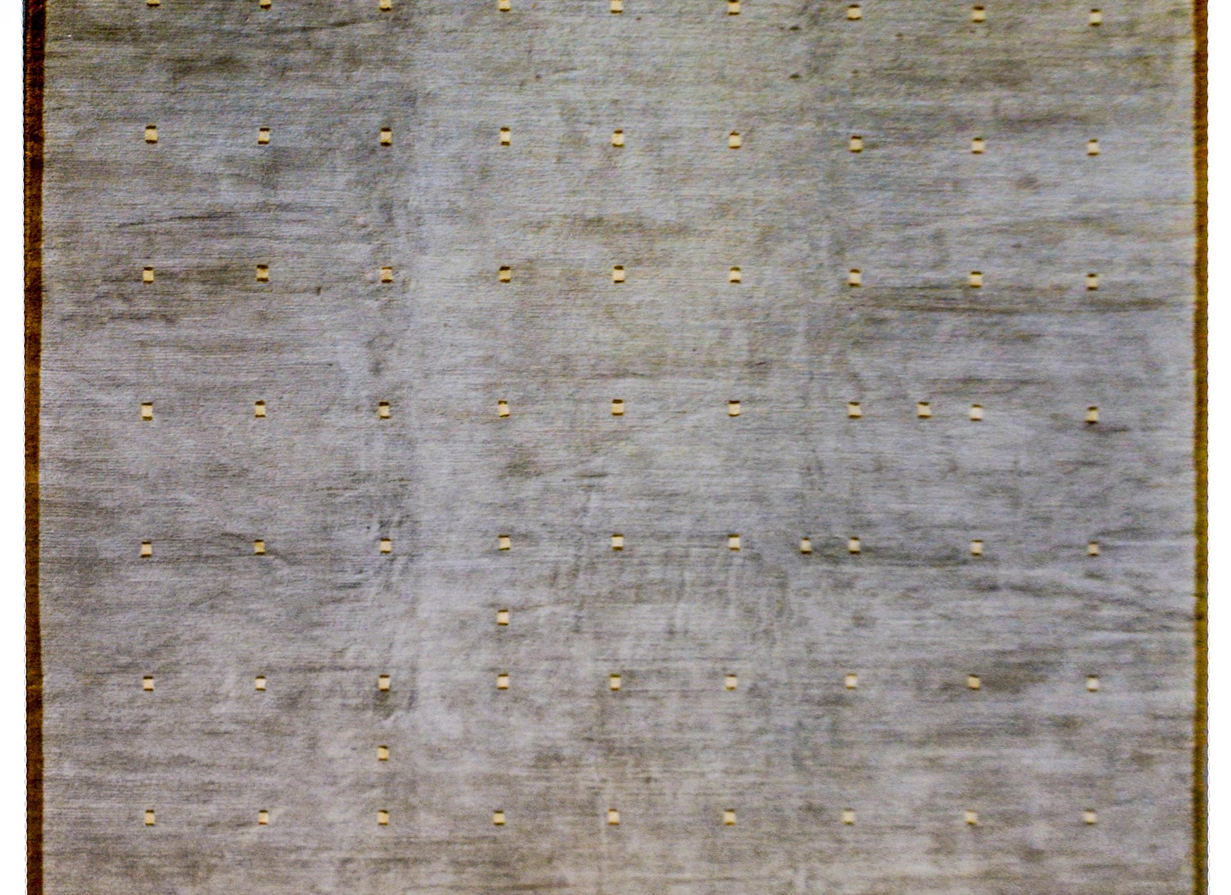 Ein zeitgenössischer tibetischer Teppich mit schickem taupe-grauem Grund, der mit einem zierlichen braunen und cremefarbenen Karomuster versehen ist. Eine dünne braune Bordüre umgibt den Teppich.