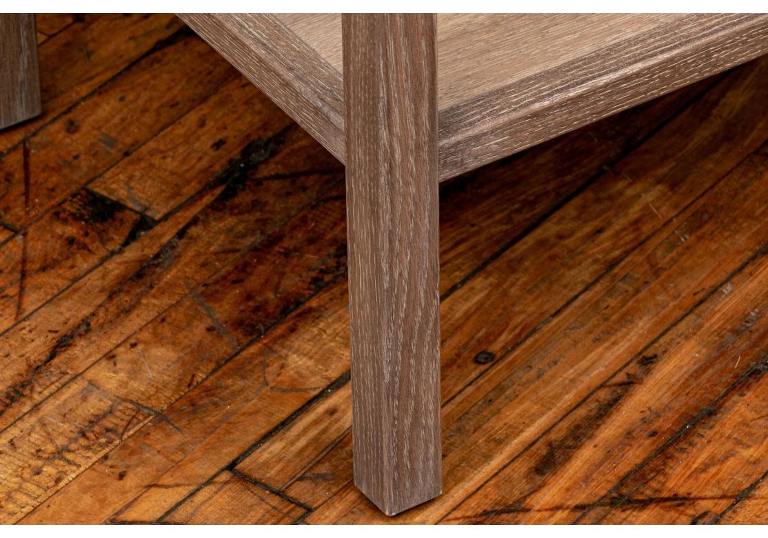 Table d'appoint rectangulaire en bois gris naturel. Le plateau, semblable à un plateau, présente une galerie angulaire sculptée encadrant un plateau tissé laqué blanc. L'étage inférieur en bois naturel. Il repose sur de grands pieds carrés.