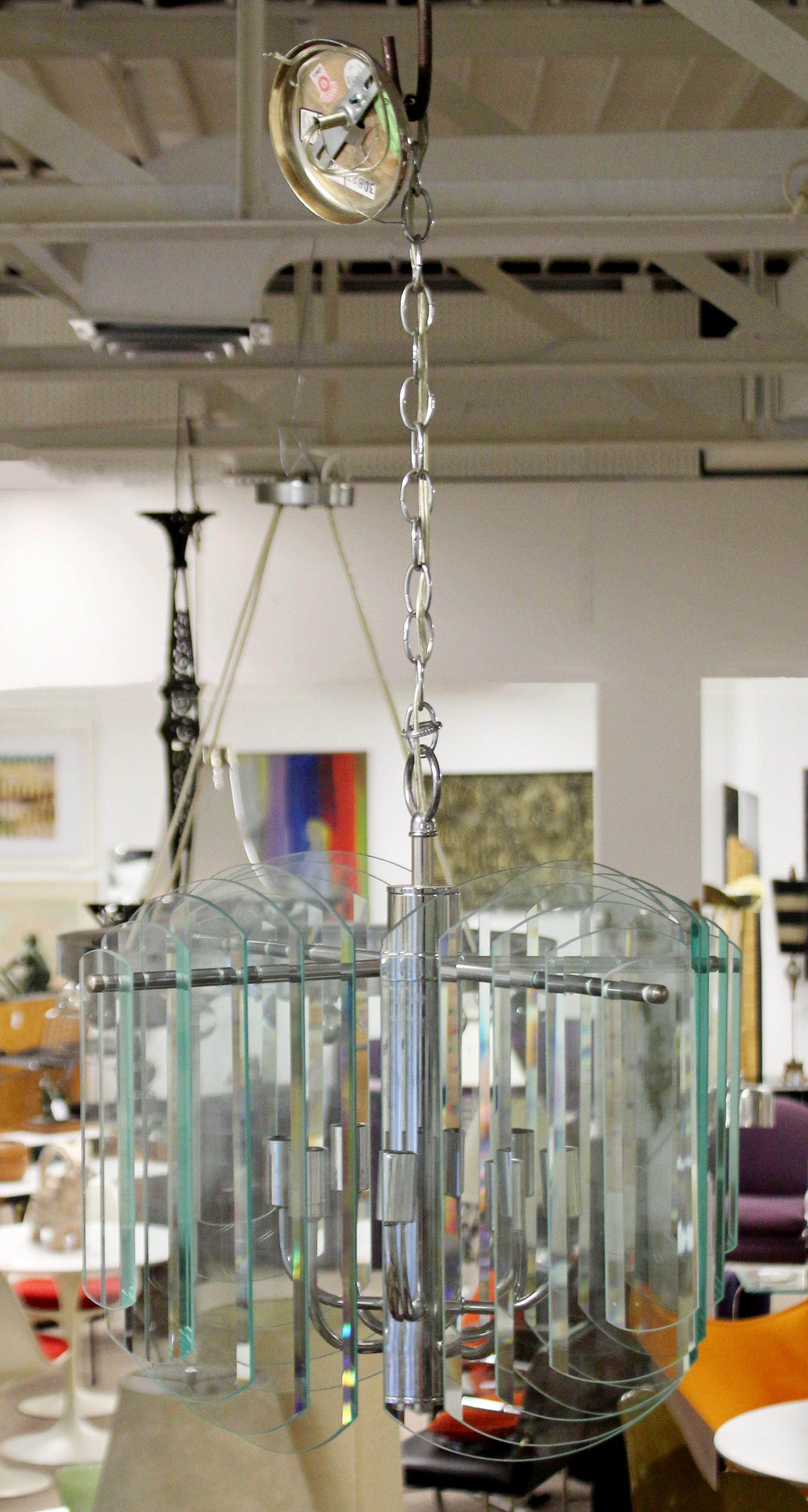 For your consideration is a majestic looking, multi layered glass and chrome chandelier by Luminaire. In excellent condition. The dimensions are 21