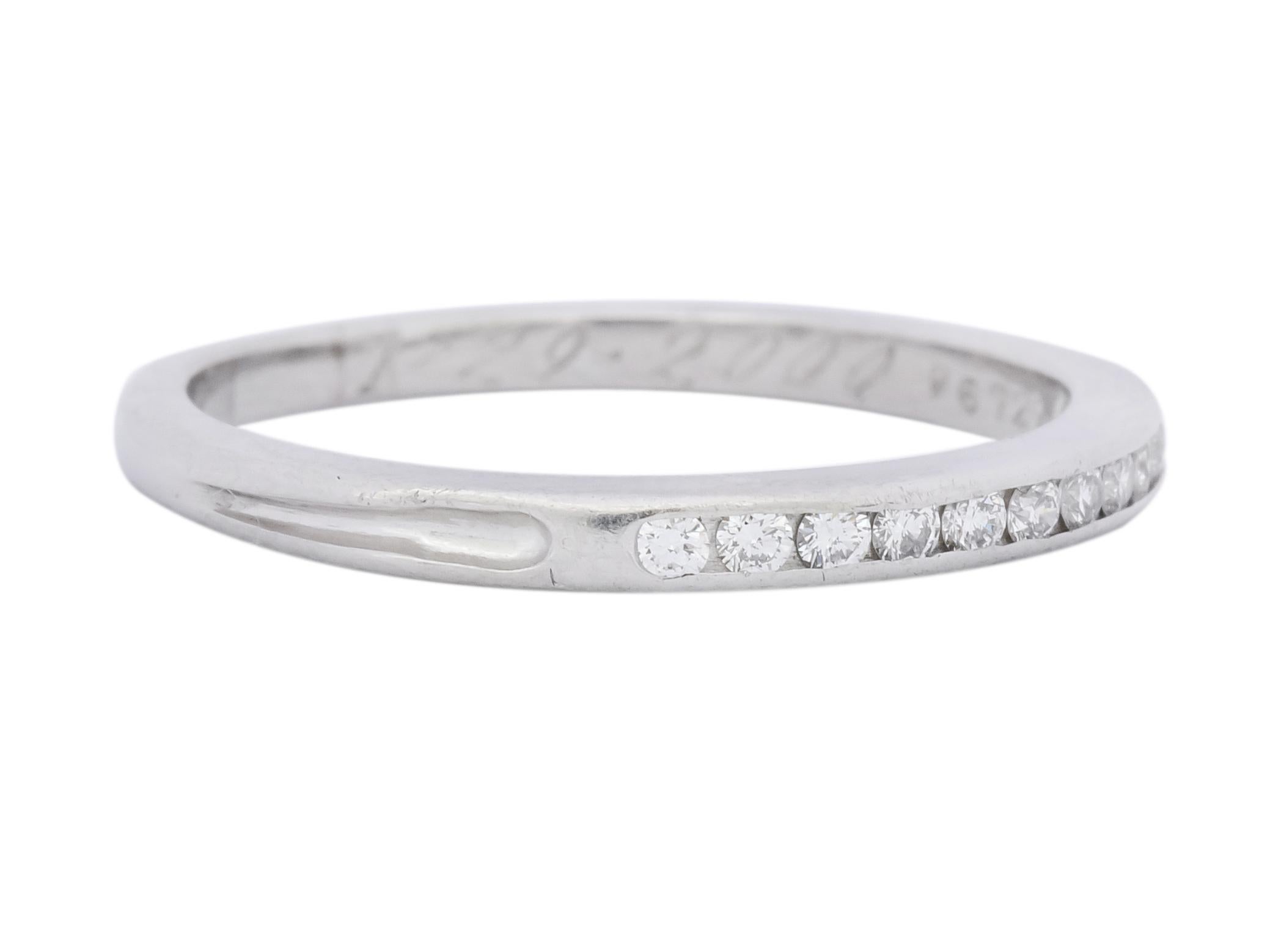Round brilliant cut diamonds, channel set to front, weighing approximately 0.22 carat total, E/F color and VS clarity

Accented by deeply recessed grooves on each shoulder

With dated inscription circa 2000

Fully signed Tiffany & Co. and