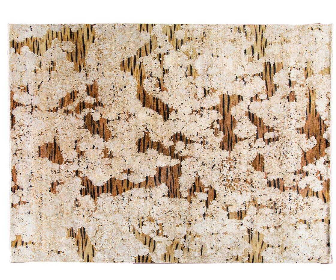 This contemporary tiger wool and silk Indian rug in brown, creme and black transforms this ubiquitous animal motif into couture for your floor. The hand- knotted, tiger patterned wool ground in mottled shades of rust, tan, brown and black, undulates
