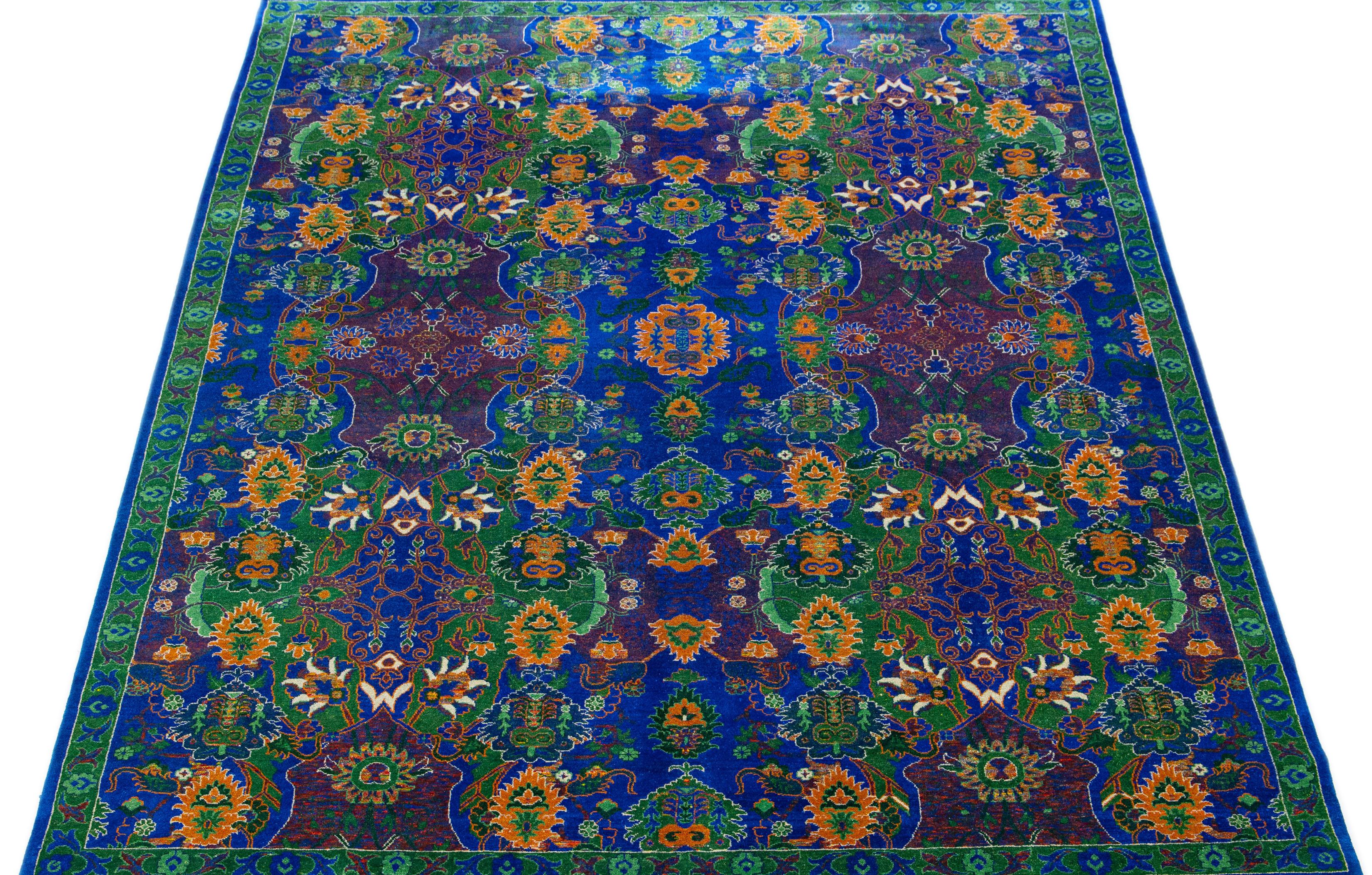 Stunning in its contemporary style, this wool and silk rug showcases a mesmerizing abstract design in a captivating shade of blue. Its allure is heightened by the exquisitely crafted orange and green accents that effortlessly harmonize with the