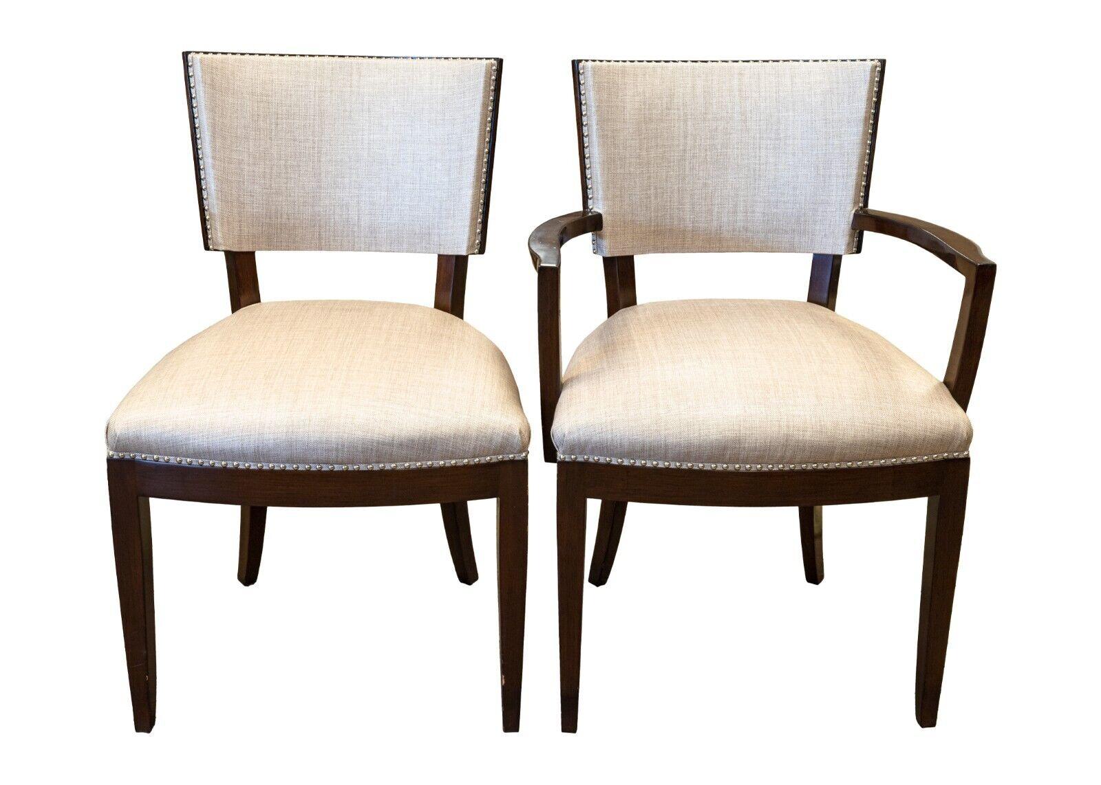 A set of 6 A. Rudin wood dining room chairs. This handsome set of dining room chairs feature two styles of chair. There are two end chairs which feature arms, and four side chairs that do not have arms. These chairs are constructed with a dark wood
