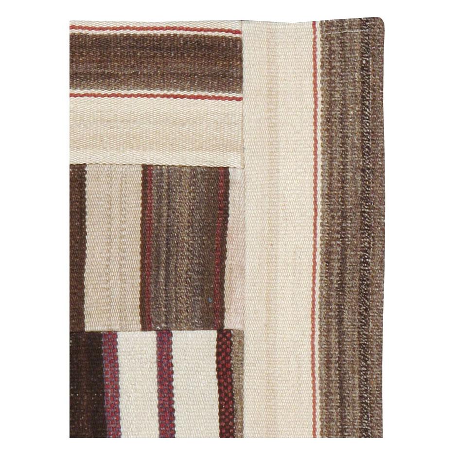 A contemporary Turkish flatweave Kilim throw rug handmade during the 21st century. This patchwork-style rug consists of hand-weaving together several remnants of vintage Kilim carpets from the mid-20th century period.

Measures: 2' 2