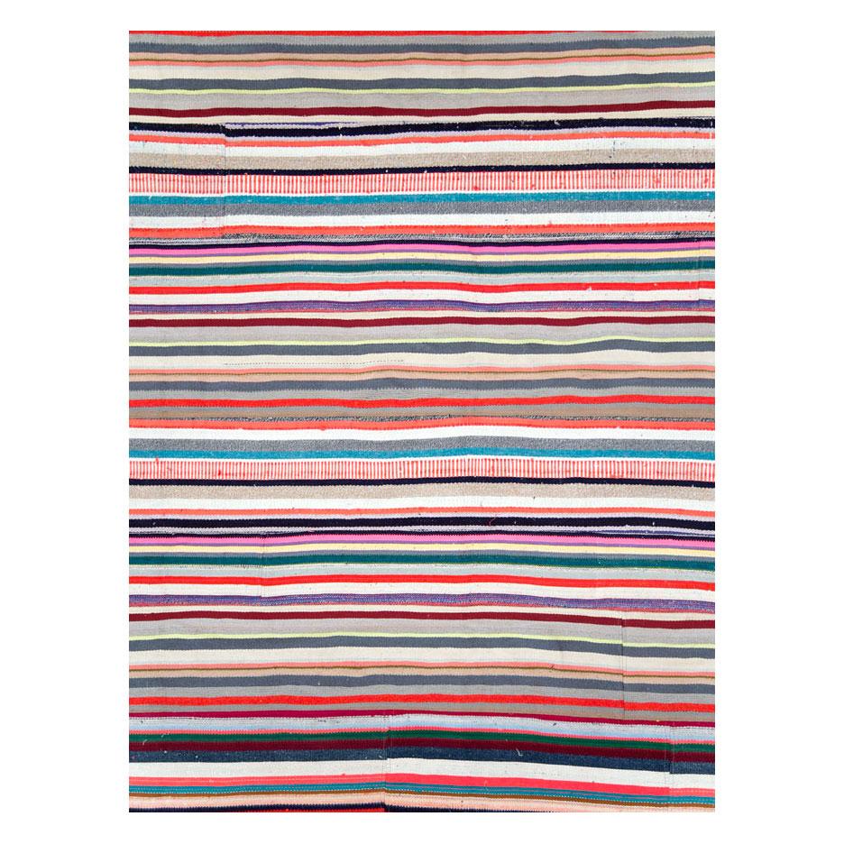 Un tapis Kilim turc moderne, tissé à plat et de grande taille, fait à la main au cours du 21ème siècle dans un style patchwork. Le design contemporain utilise des rayures horizontales dans plusieurs couleurs vives, entrecoupées de courtes lignes