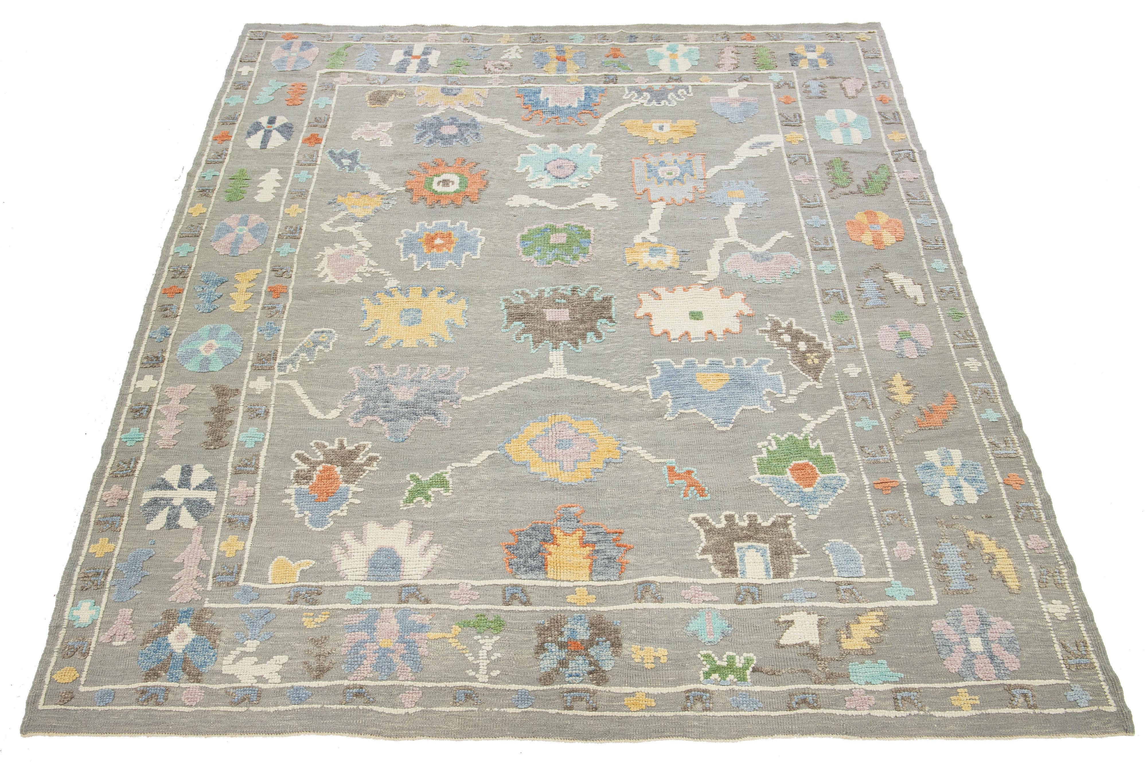 This Turkish hand-knotted wool rug showcases a light gray background adorned with a captivating multicolor floral pattern, making it an ideal addition to any decor.

This rug measures 9'5