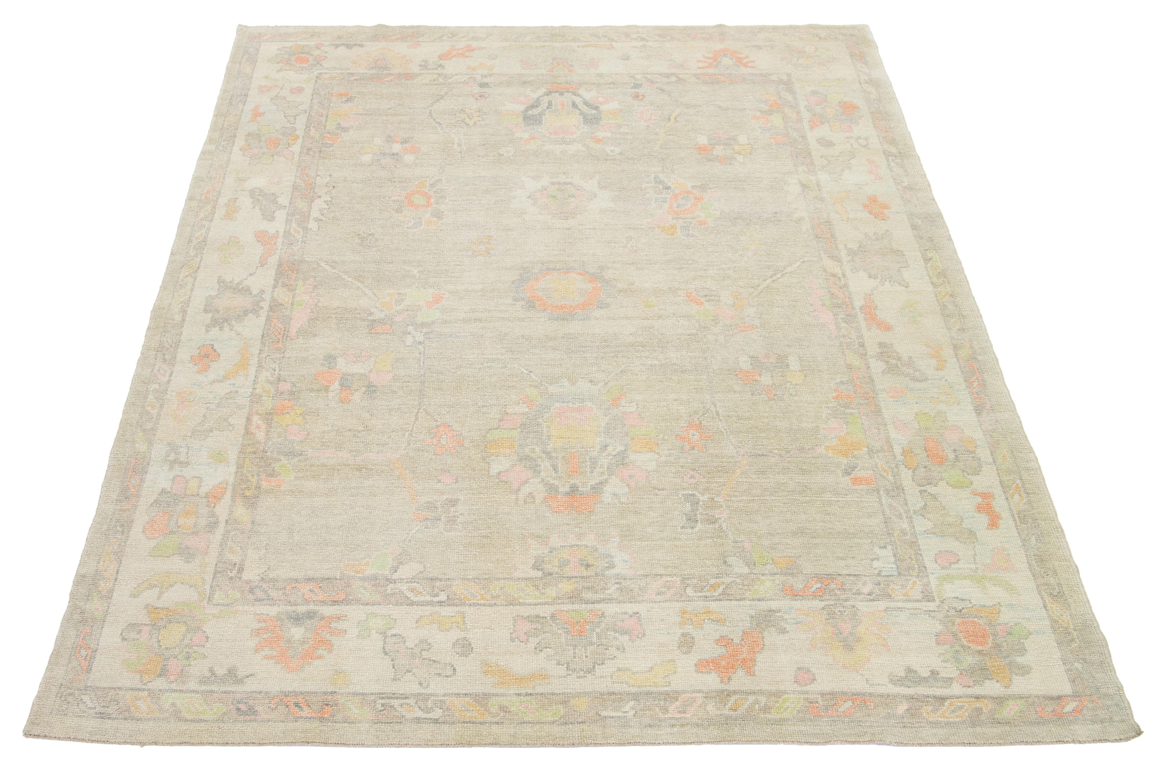 Esta moderna alfombra turca de lana anudada a mano muestra un campo beige con un cautivador motivo floral multicolor.

Esta alfombra mide 8'10
