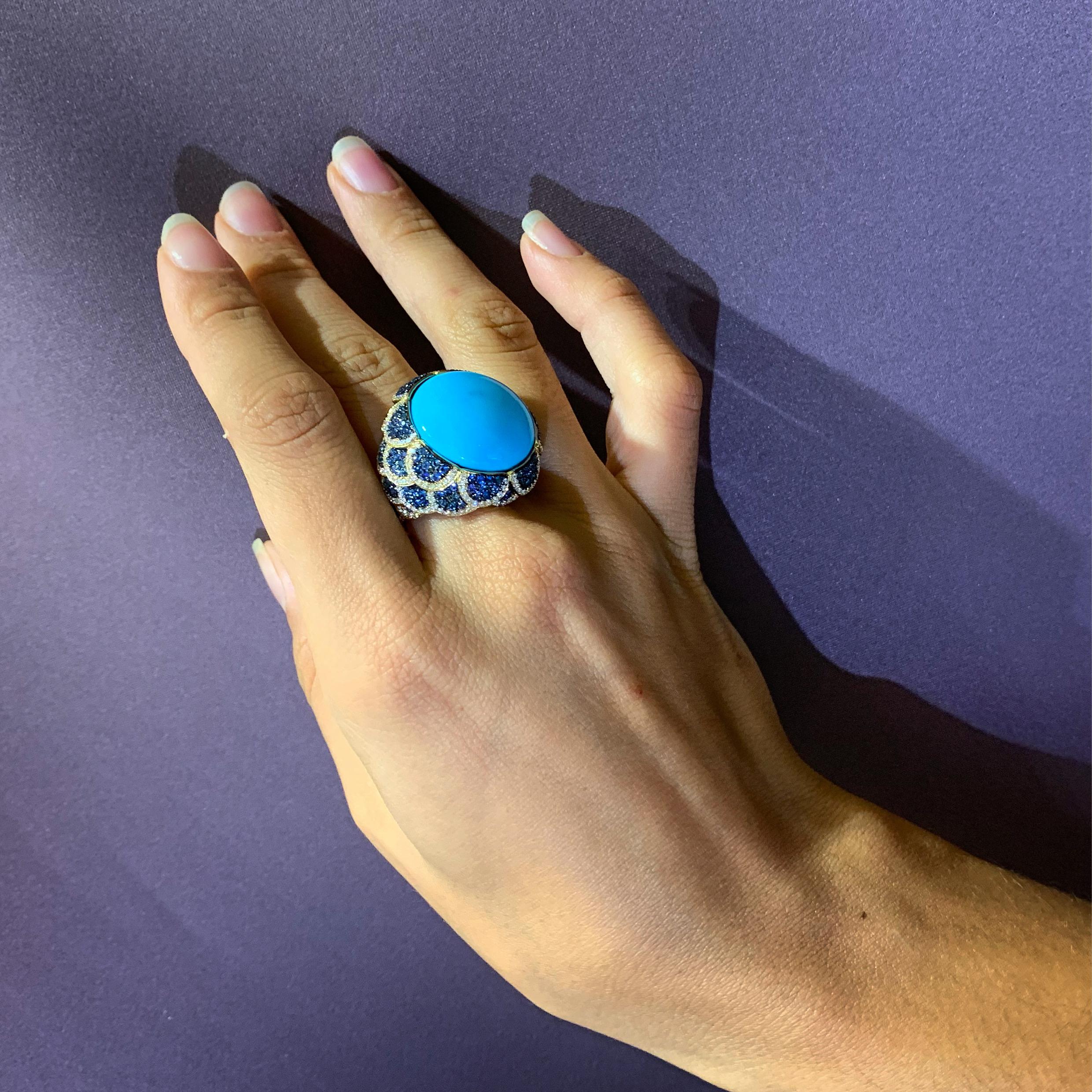 Rosior by Manuel Rosas Contemporary Cocktail Ring made in 19.2 Karat Yellow Gold featuring a Round Cut Turquoise with 17,81 ct and:
- 250 Diamonds (F Color, VVS clarity) with 1,04 ct,
- 172 Blue Sapphires with 2,22 ct.
Black Rhodium Finnishing.