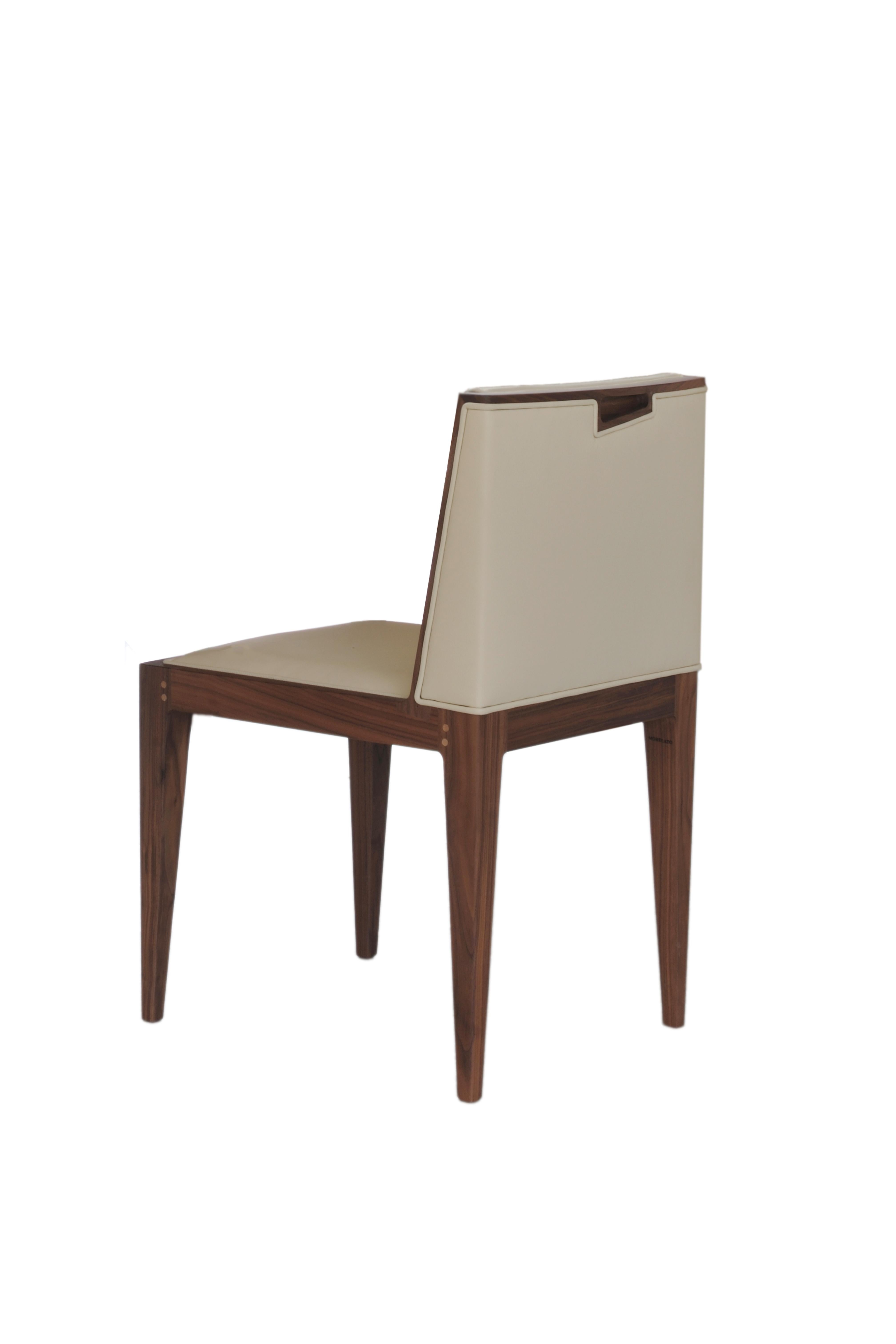 Contemporary upholstered chair made of ash wood. 
Padded cushion and backrest, upholstered with leather or fabric.
Special handle carved in the backrest.
Customizable with different wood finishes and coating materials/colors
Made in Italy by