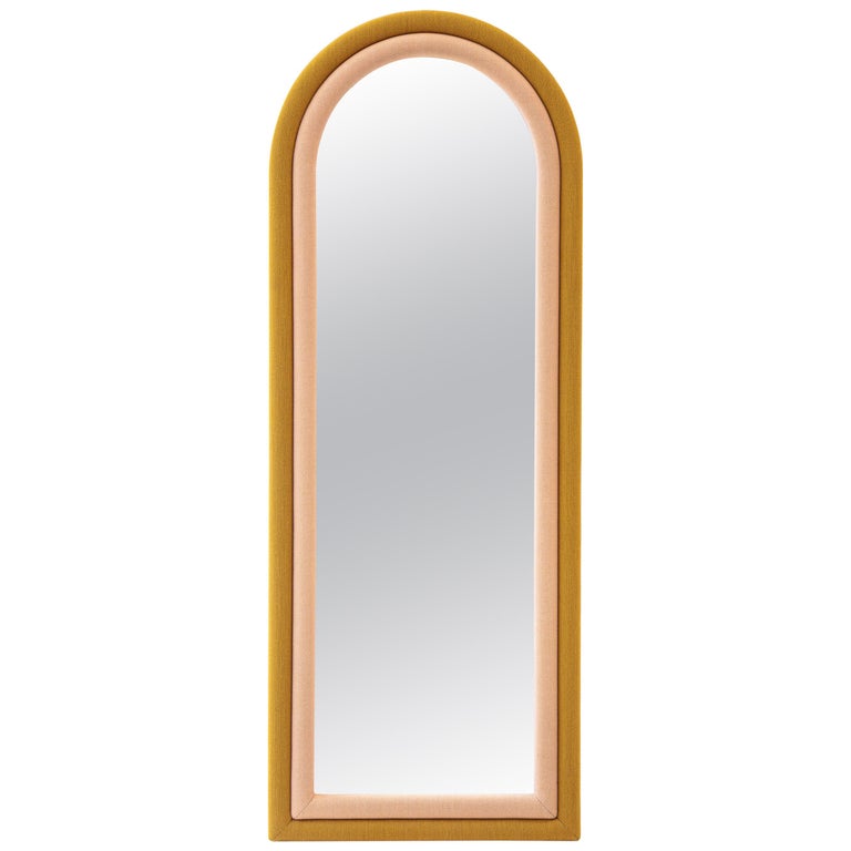 The floor version of the “Iris Mirror” has pink and mustard color upholstery wrapped around the arched shape. It can be hanged on the wall or stand by itself. It can be customized in fabrics and sizes as well.