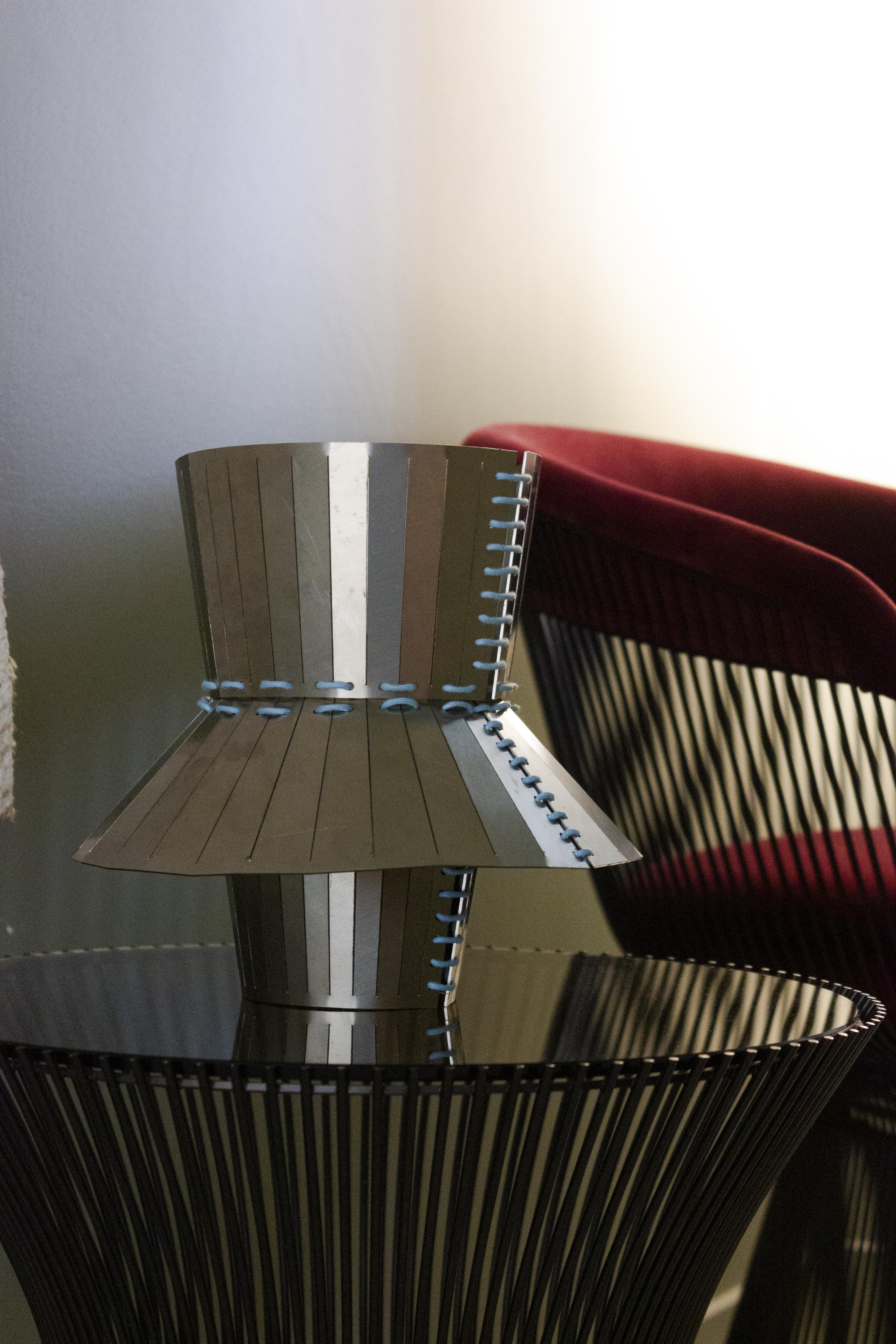 Vase en acier inoxydable de la collection Minas conçue par StudioNotte. Ce plateau aux formes épurées et multiformes est assemblé avec des coutures en corde. 
L'ensemble de la collection Minas se compose de deux centres de table et d'un plateau.