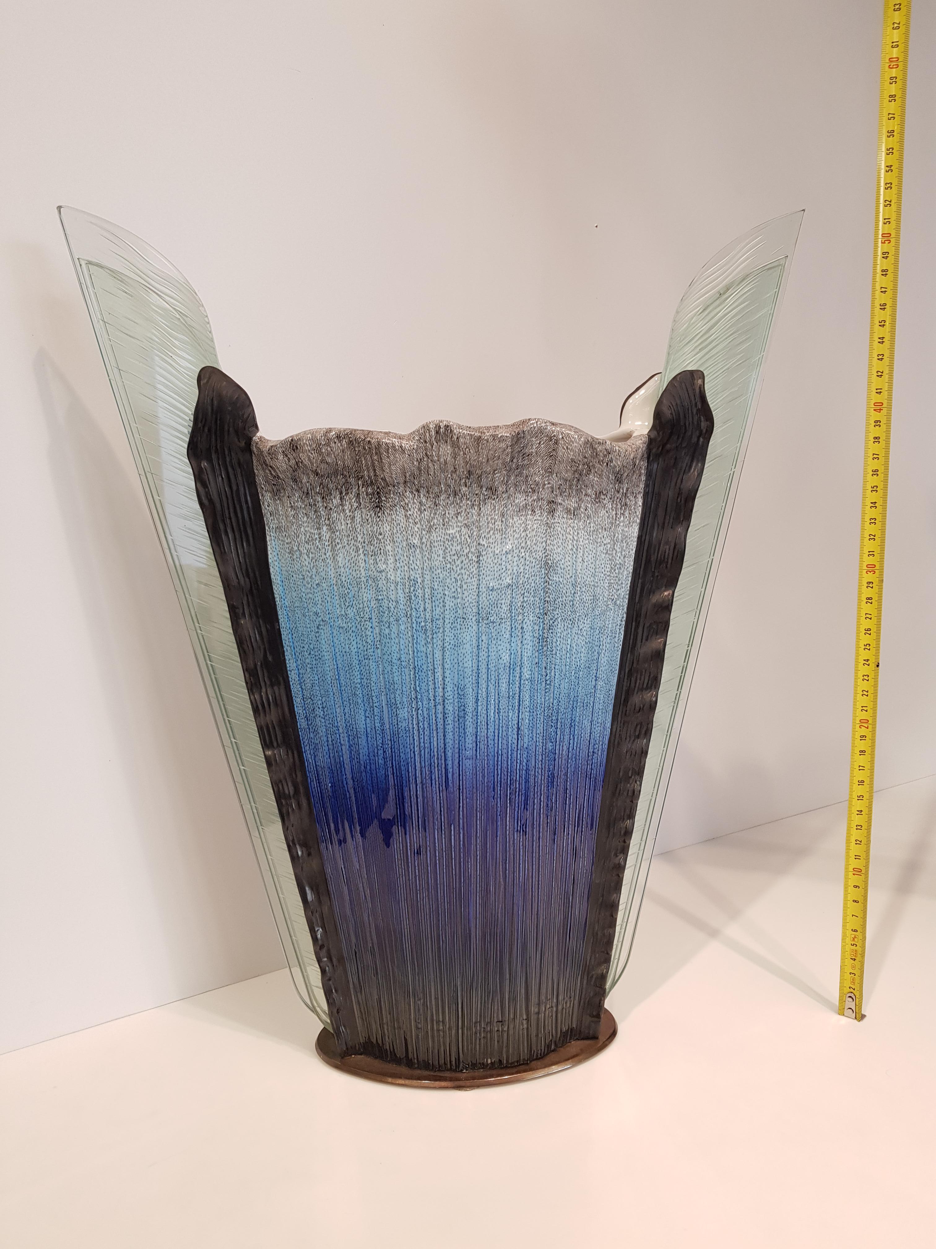 Vase made in the 1990s by the fine Mangani manufacture in Florence with the particular design signed by Annibale Oste.
Porcelain worked and decorated by hand with intense colors, they join the lightness of the glass creating a unique and
